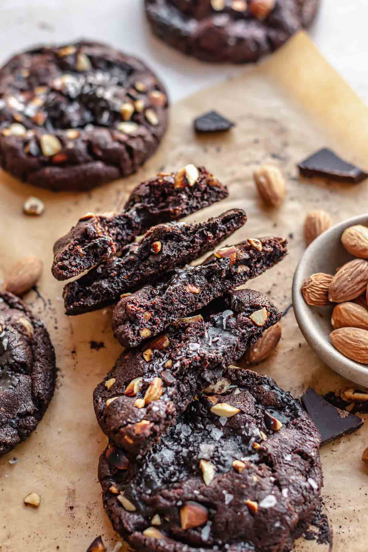 Almond chocolate cookies broken open and leaning against each other.