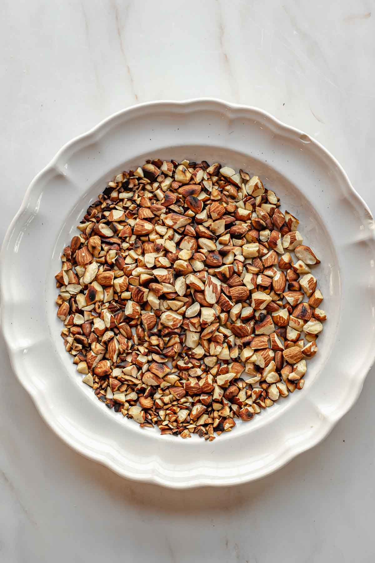 Toasted chopped almonds on a plate.