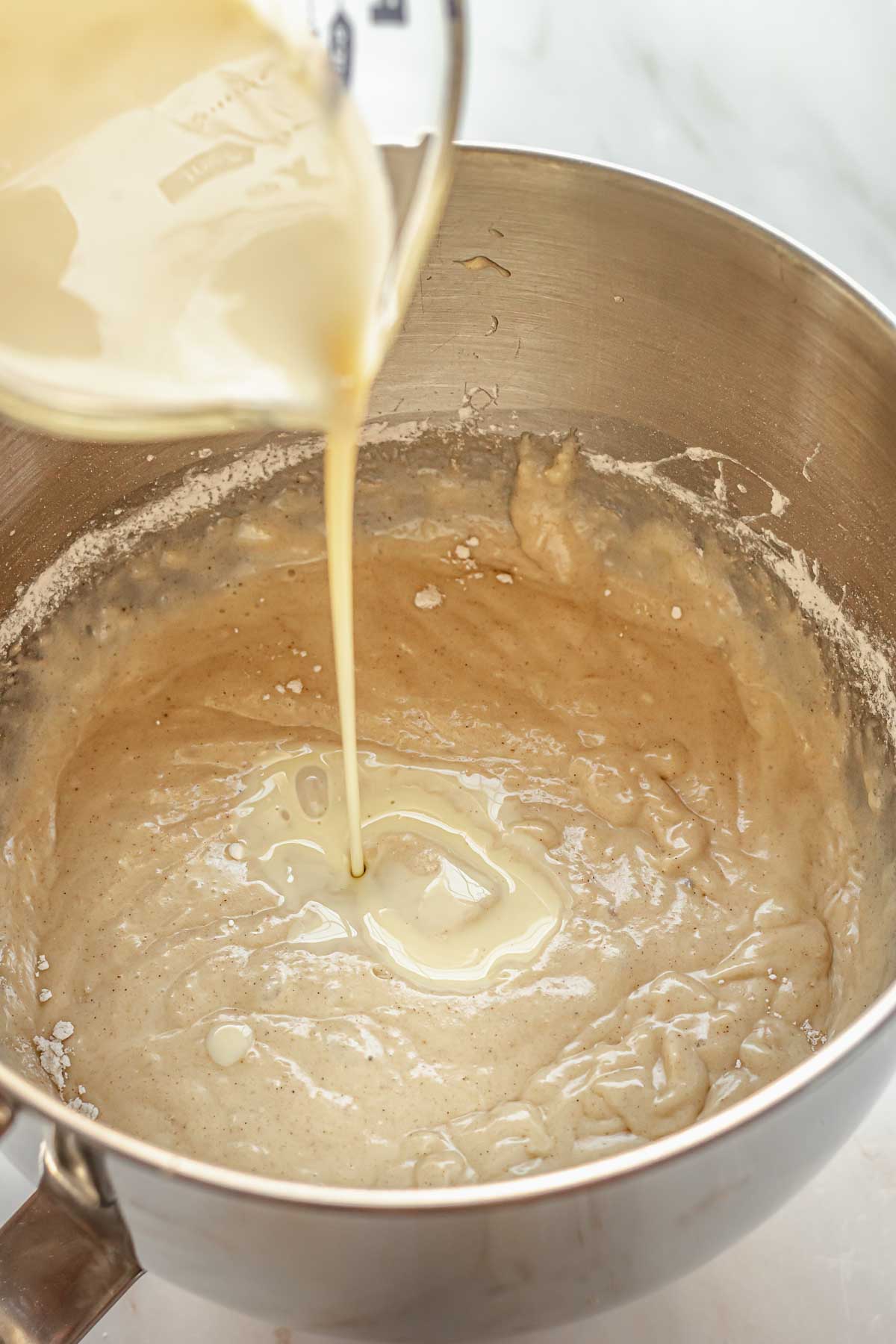 Eggnog being poured into the cake batter.