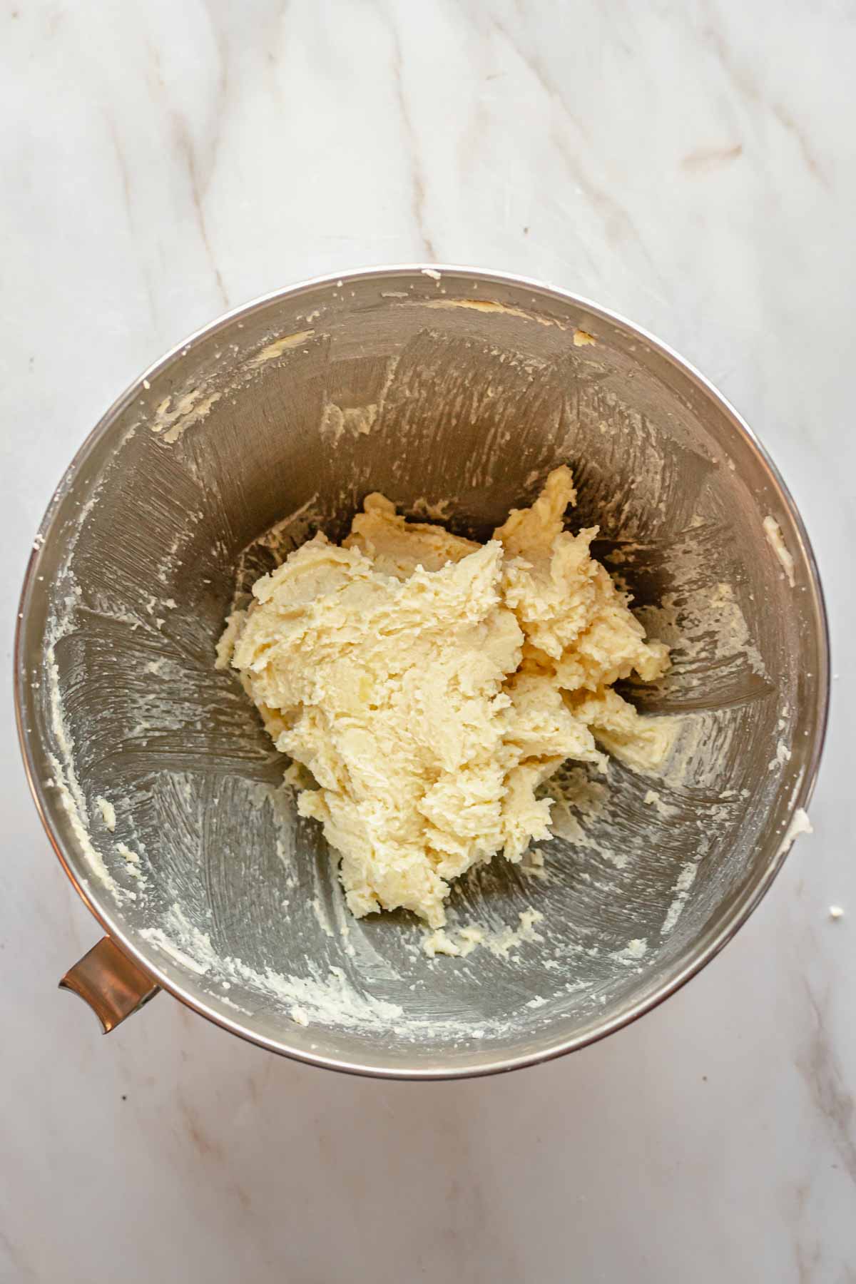 Creamed butter, sugar, and eggs in a bowl with the sides scraped down.