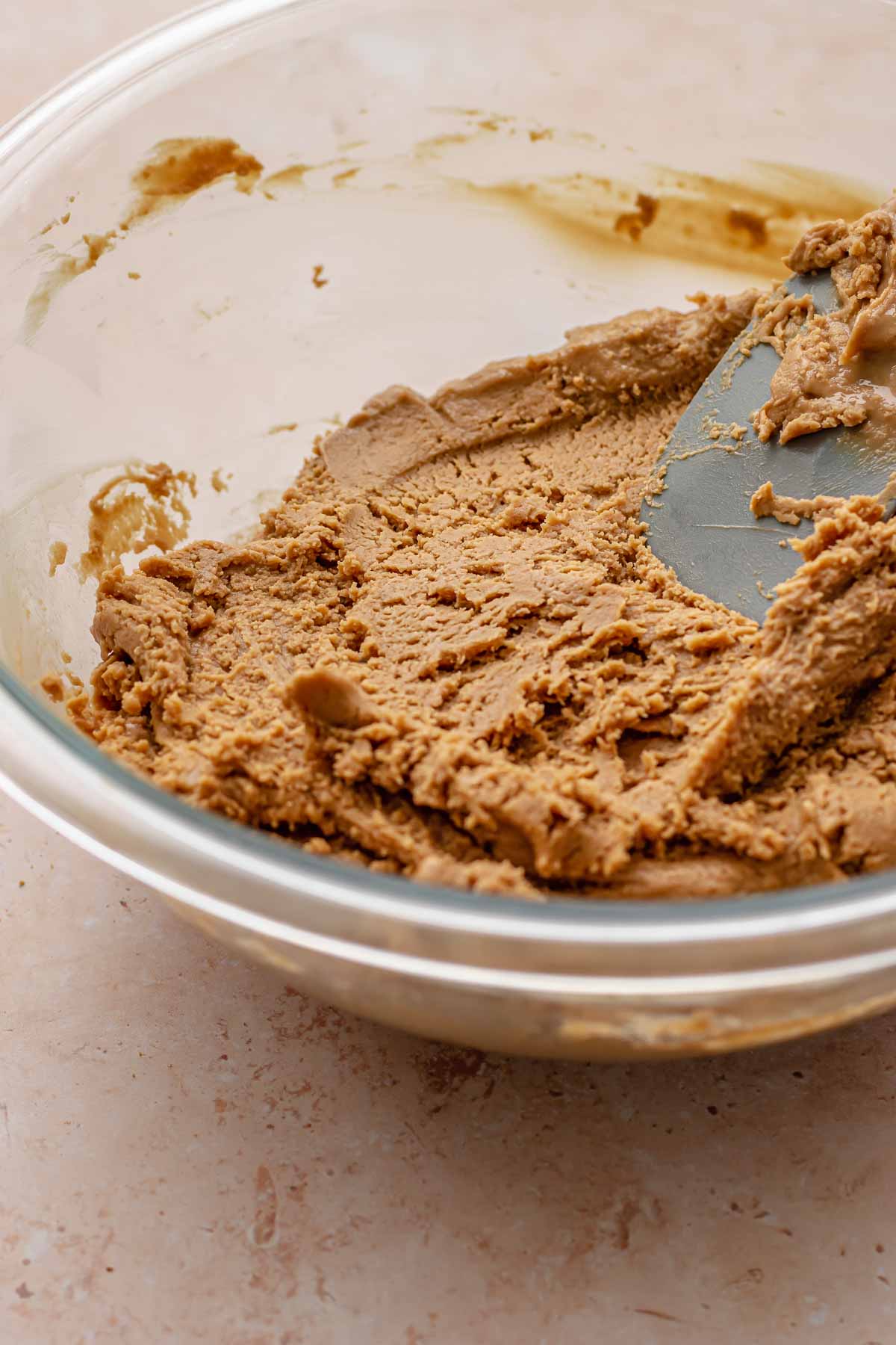 A spatula mixes cookie butter fudge in a bowl.