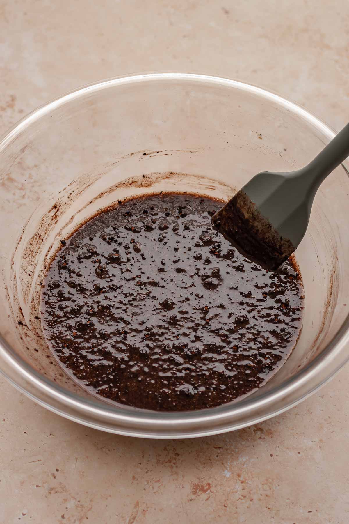 Chocolate mixture in a bowl with a spatula in the bowl.