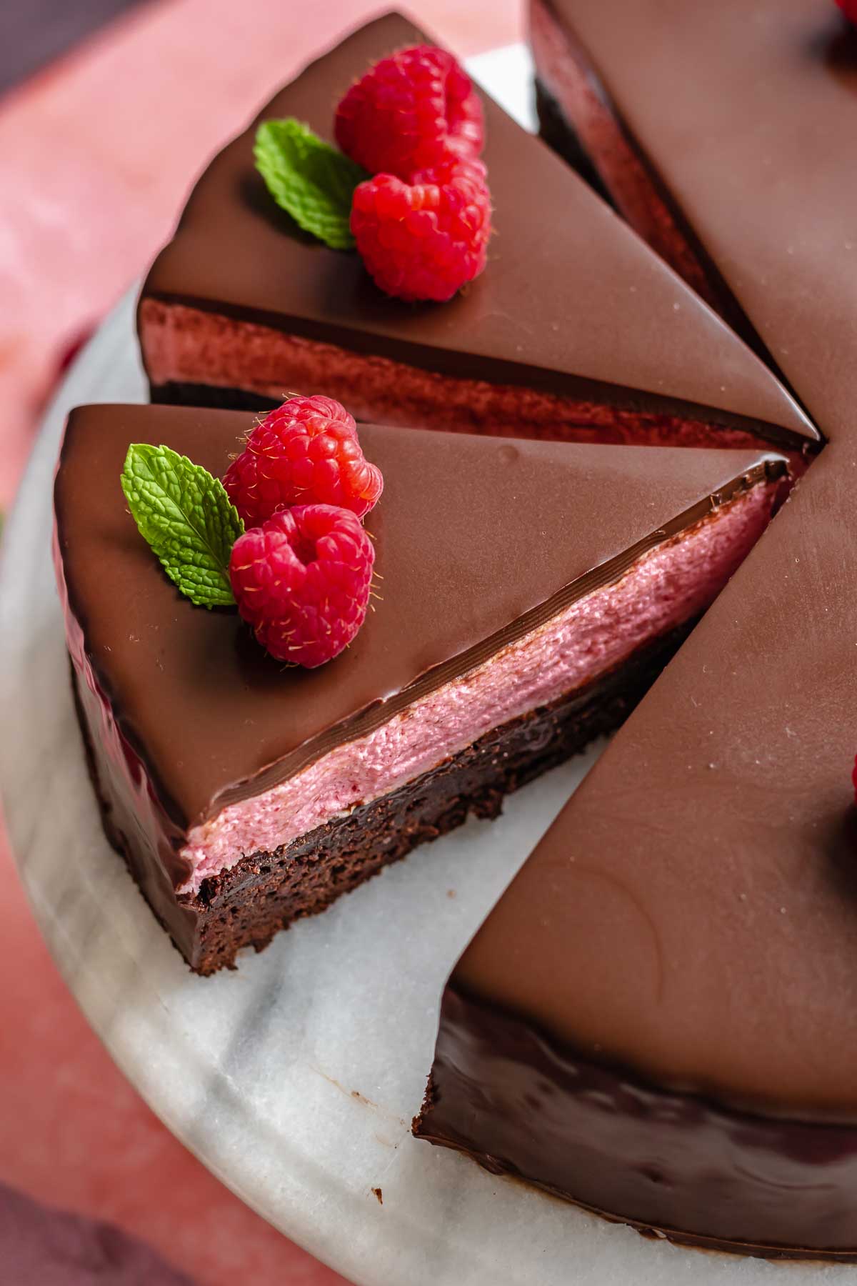 Slice of raspberry mousse cake sliced to show the inside.