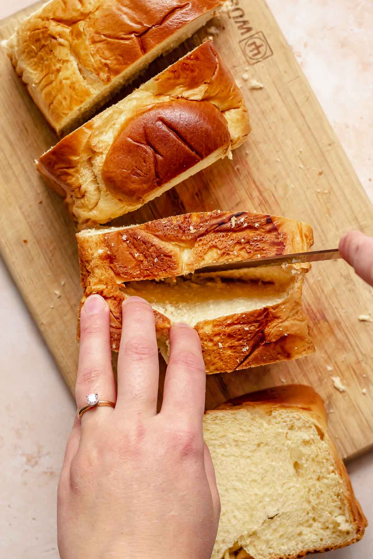 A knife cuts a pocket into a piece of brioche bread.
