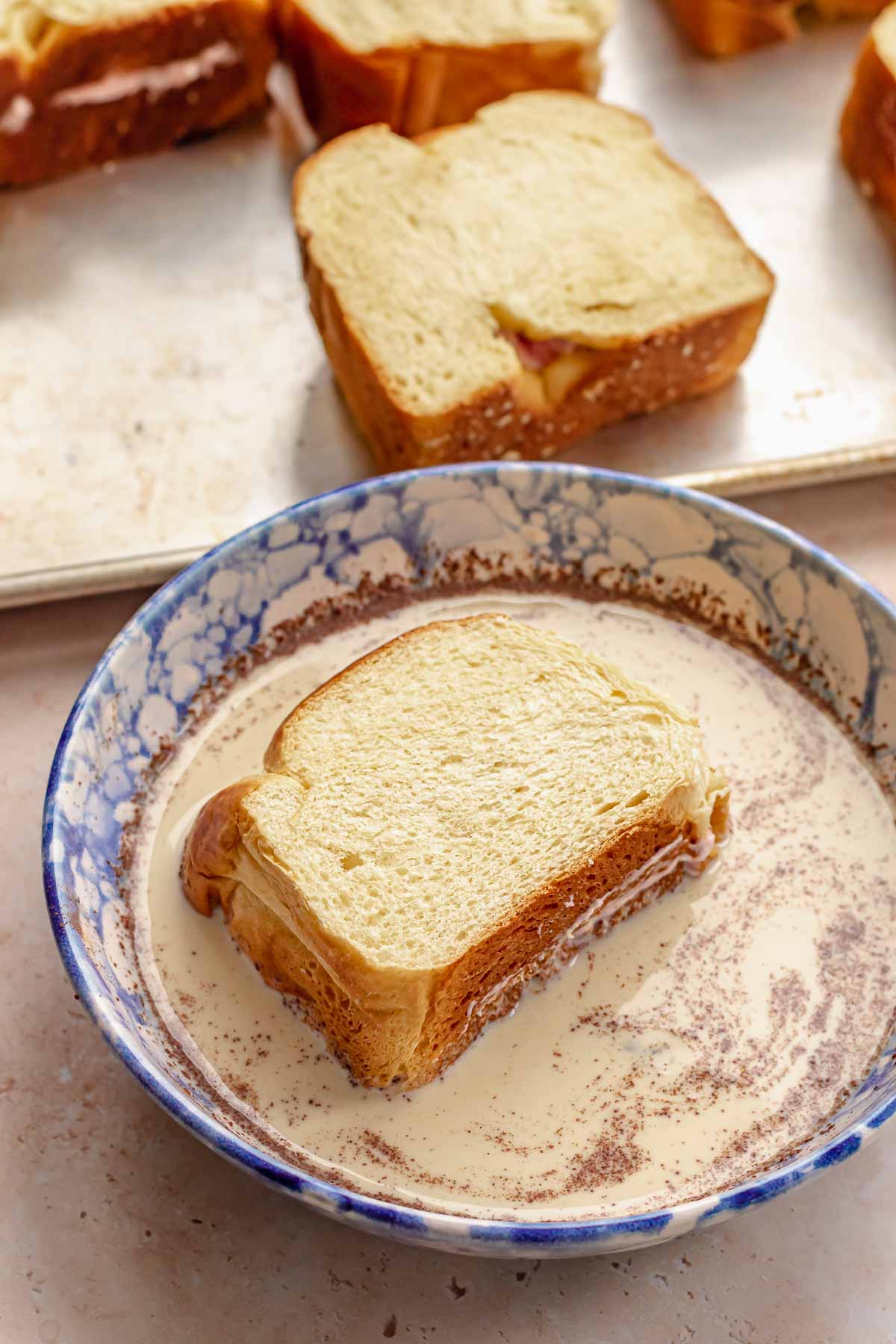 Stuffed brioche bread in custard to soak.