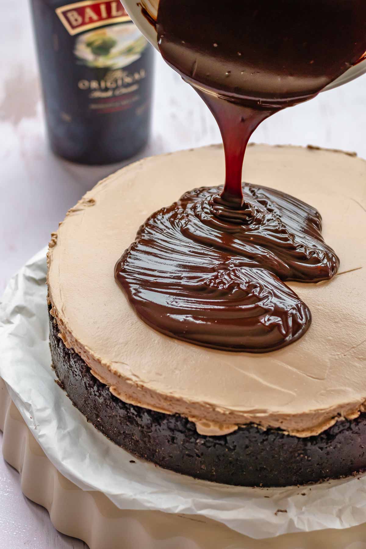 Chocolate ganache pouring on top of cheesecake.