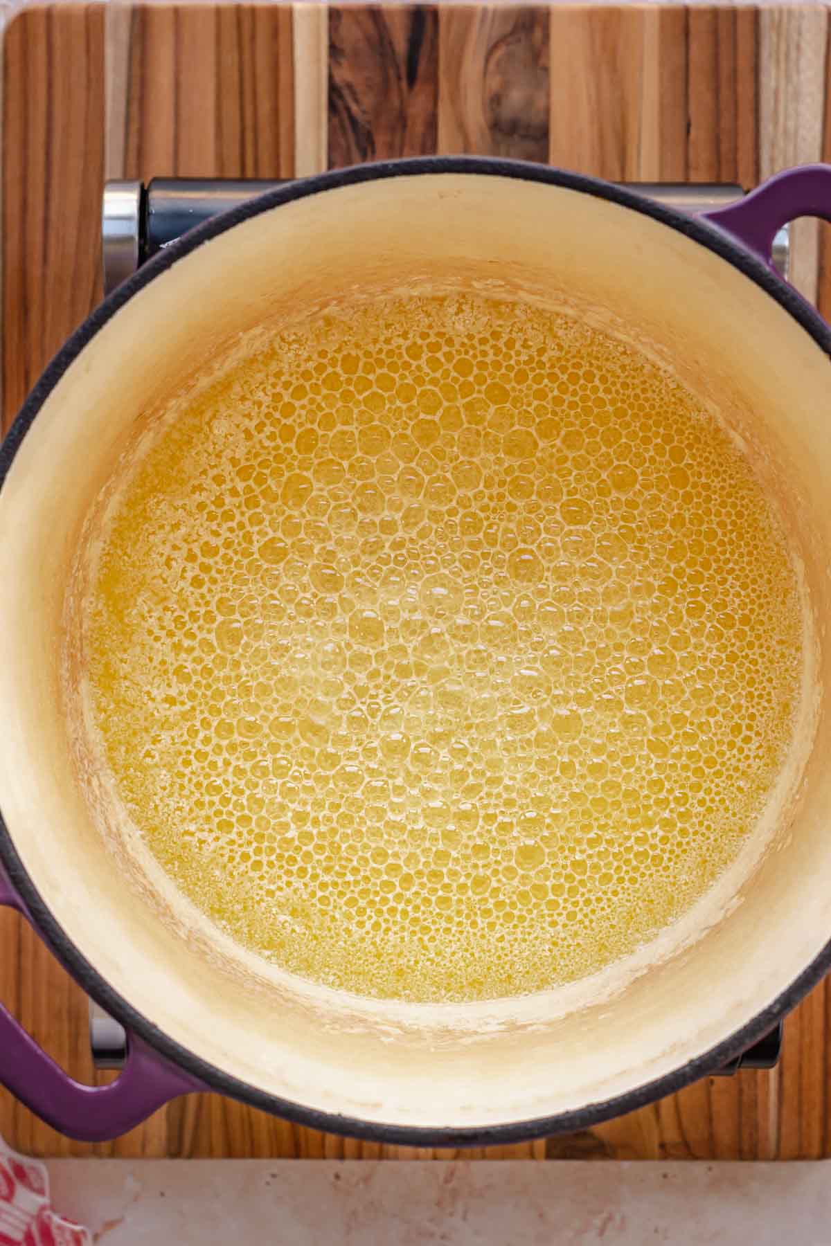 Butter melted and bubbling in a pot.
