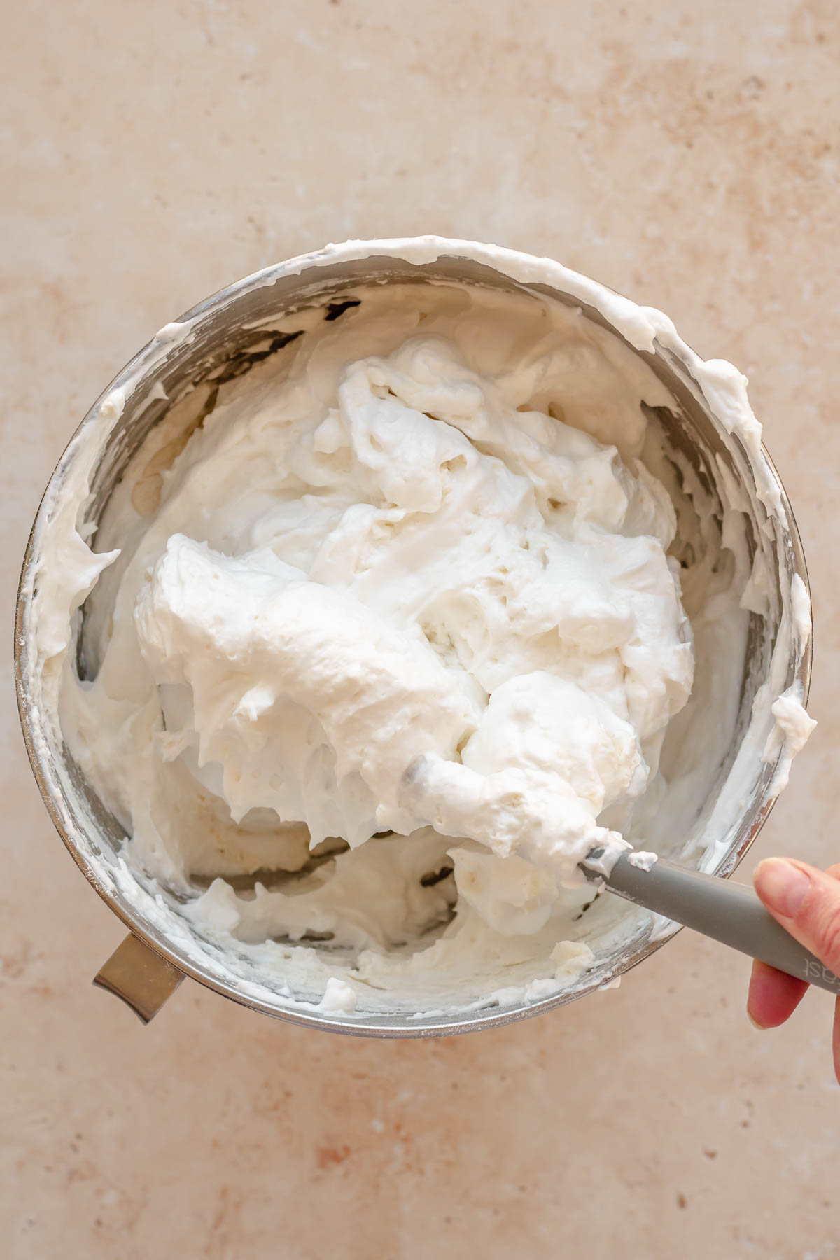 A spatula folds flour into egg whites.