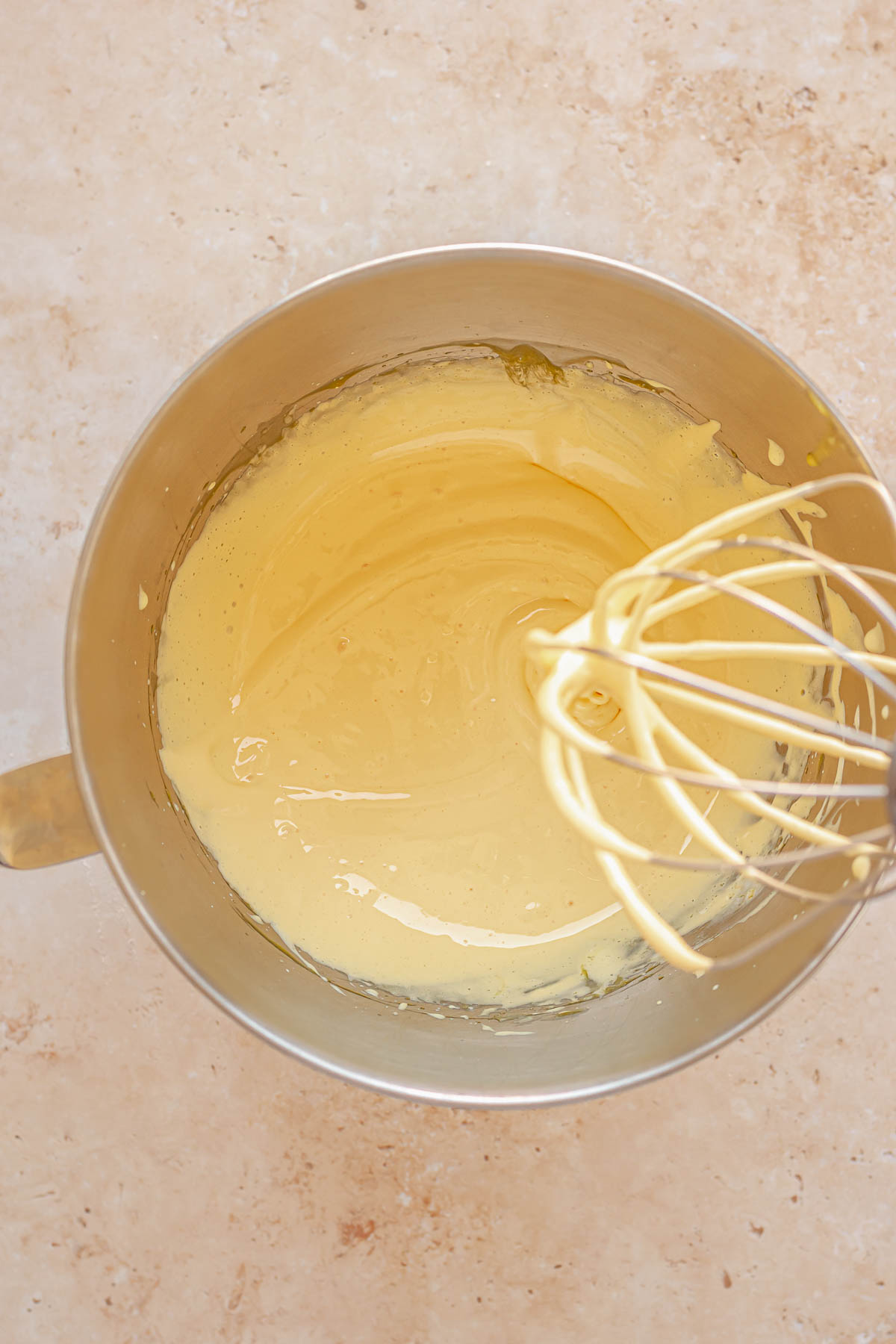 Whipped egg yolks and sugar pale in color in a bowl.