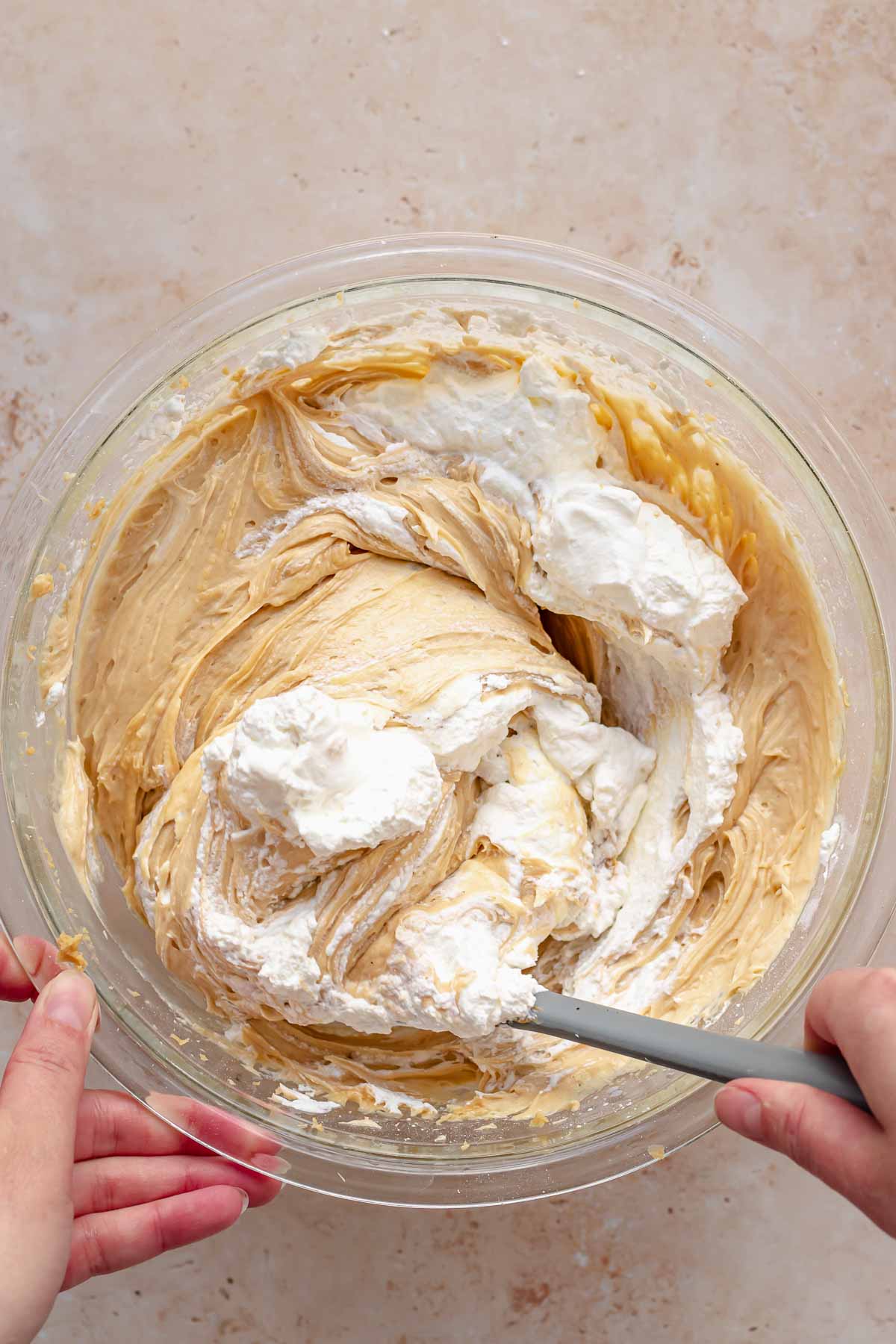 A spatula folds together peanut butter filling and whipped cream.