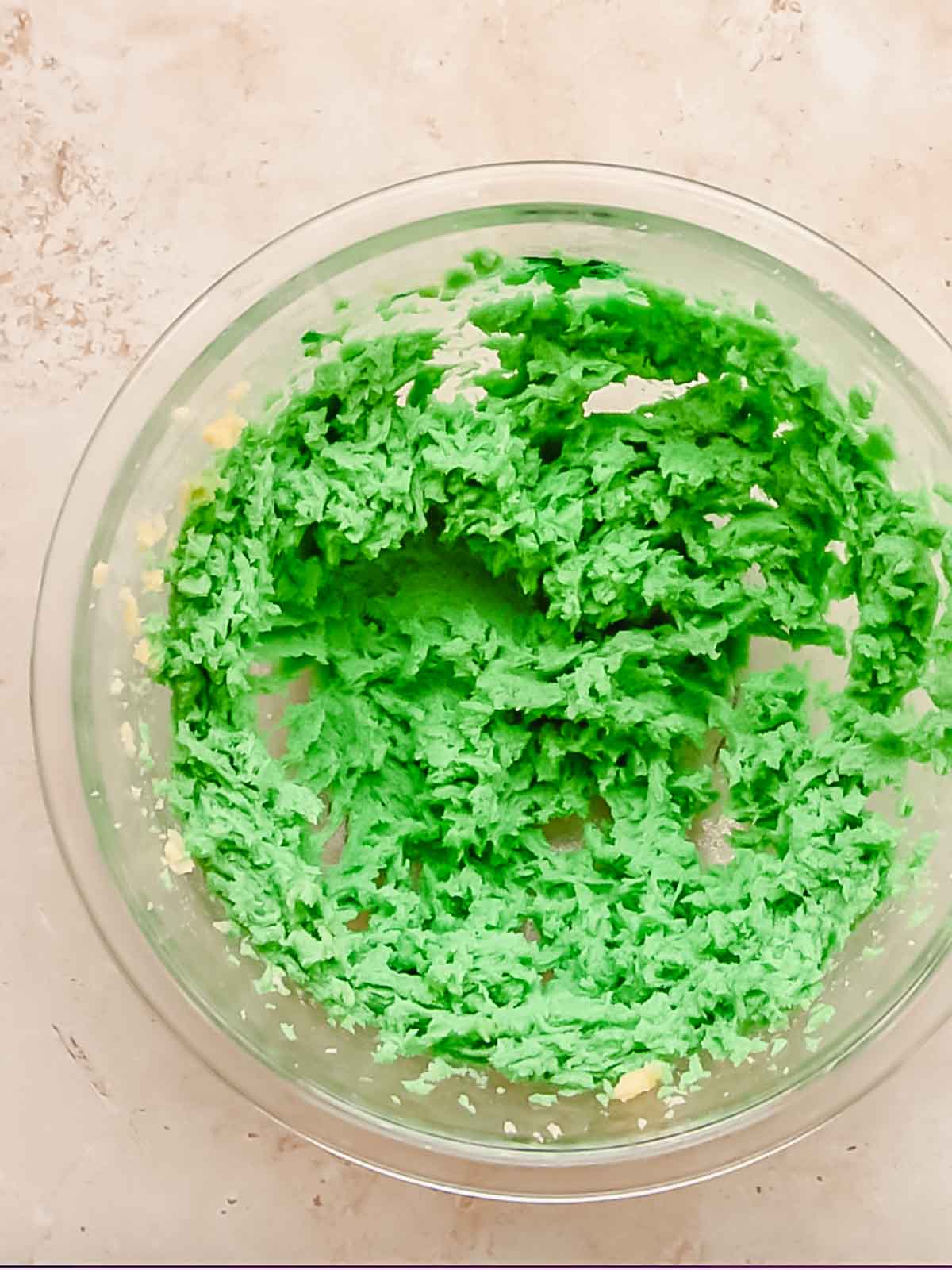 Green cookie dough in a bowl before flour is added.