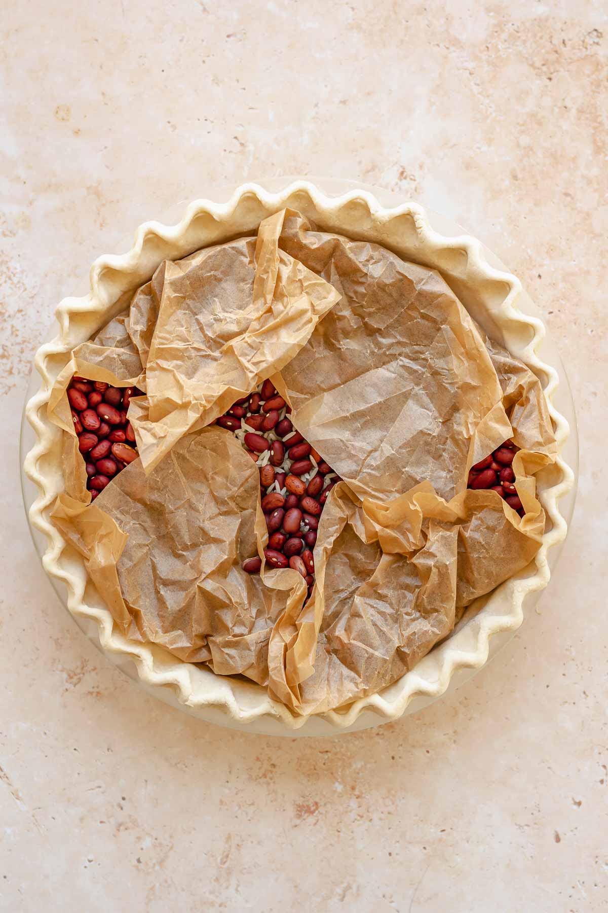 Parchment paper and pie weights in a raw pie crust.