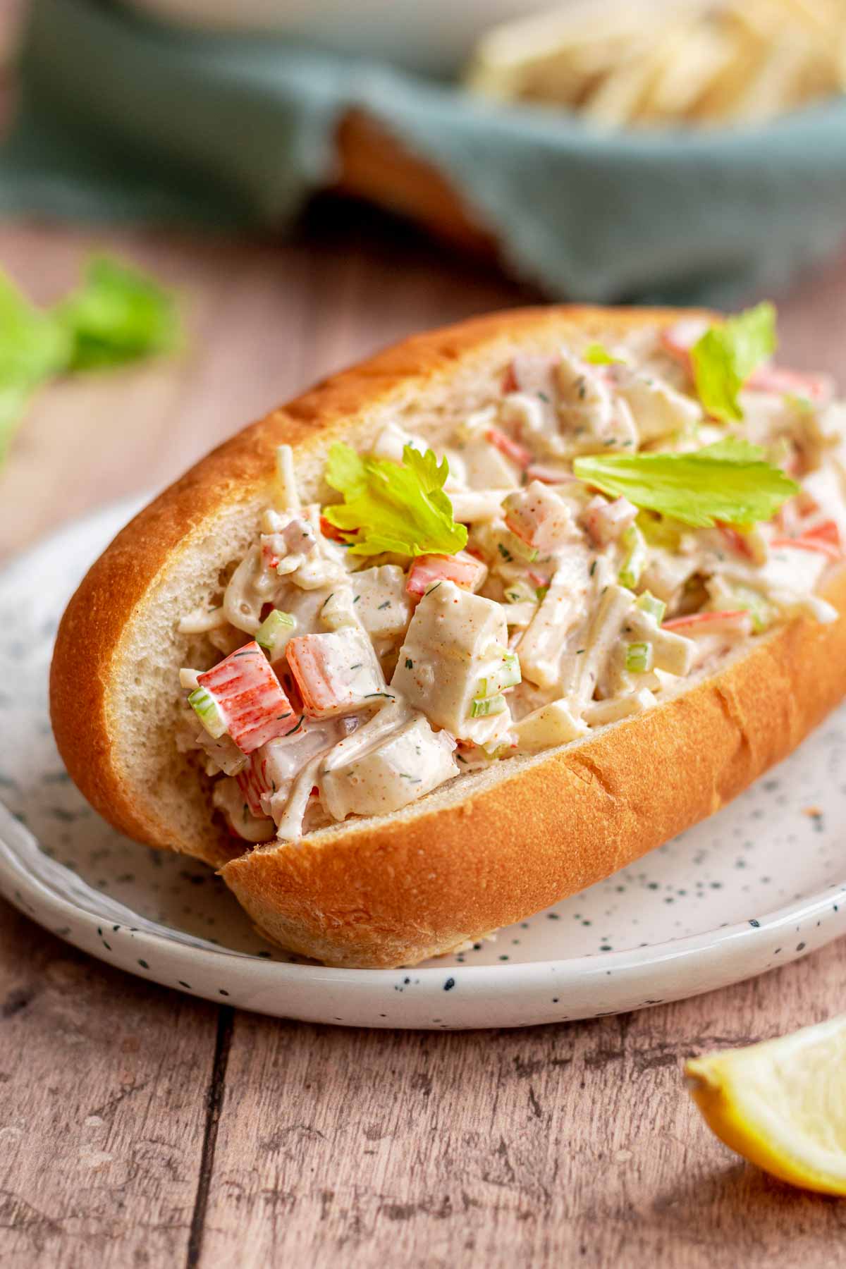 Seafood salad in a sub roll on a plate.