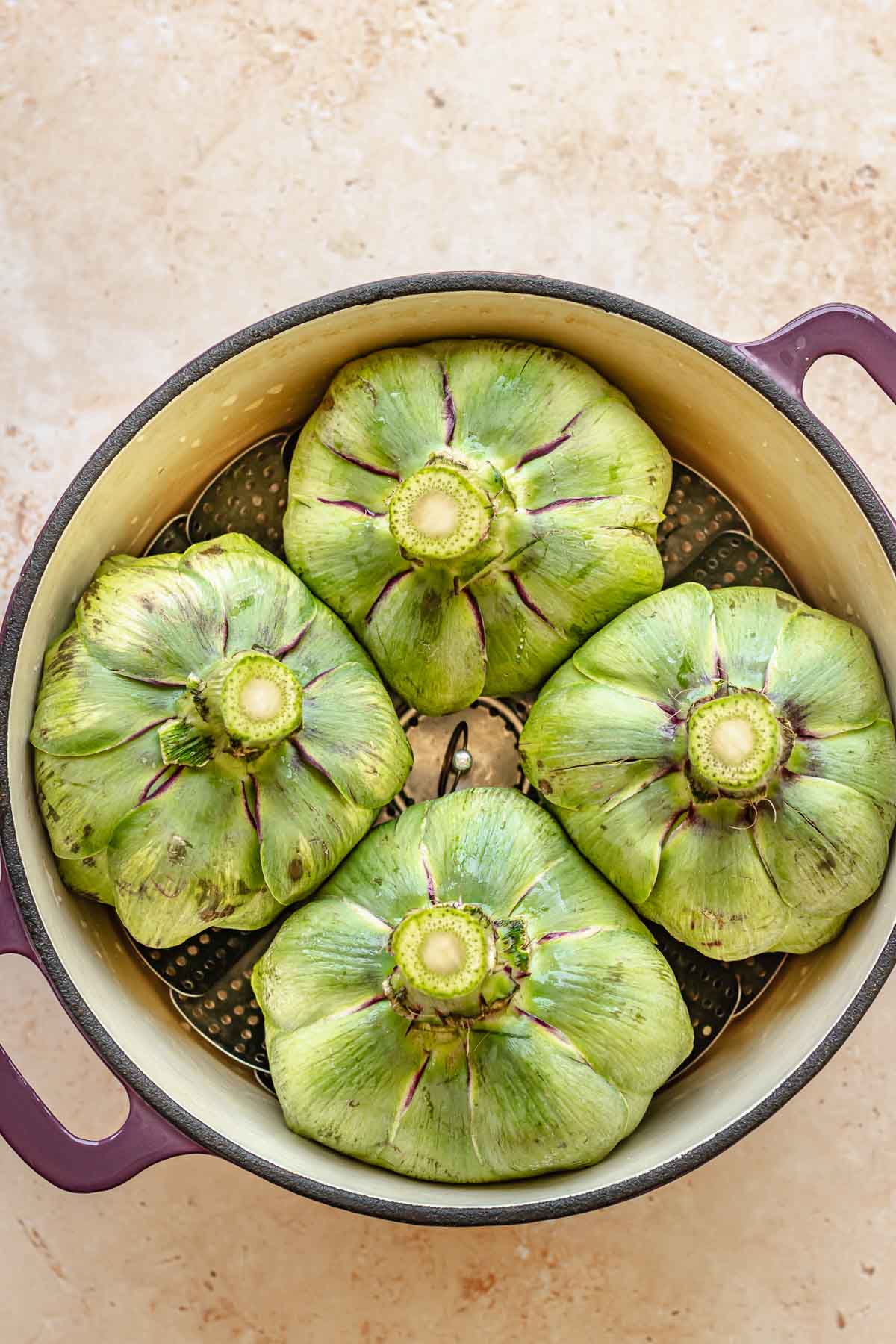 Artichokes in a pot with the bottom sides up.