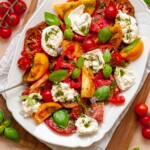 Caprese salad with burrata on a platter.