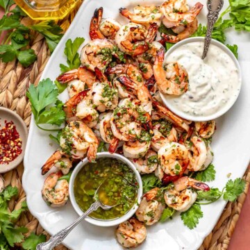Chimichurri shrimp on a platter with dipping sauces.