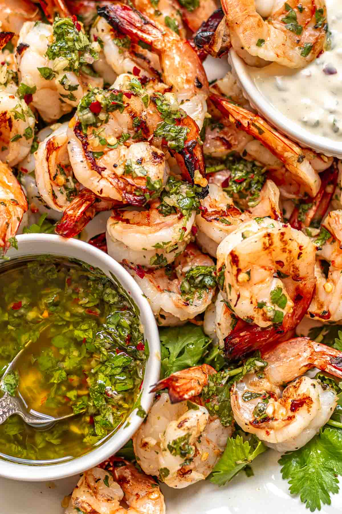 Chimichurri shrimp on a platter with dipping sauces.