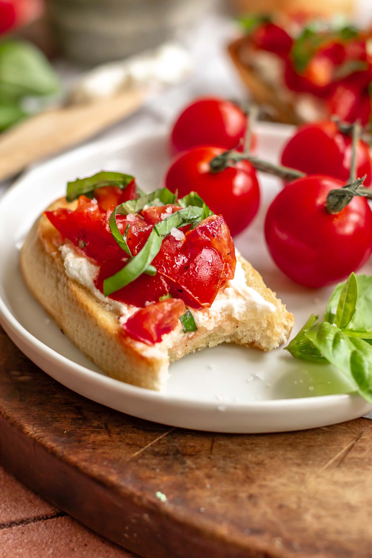 Bruschetta on a plate with a bite removed.