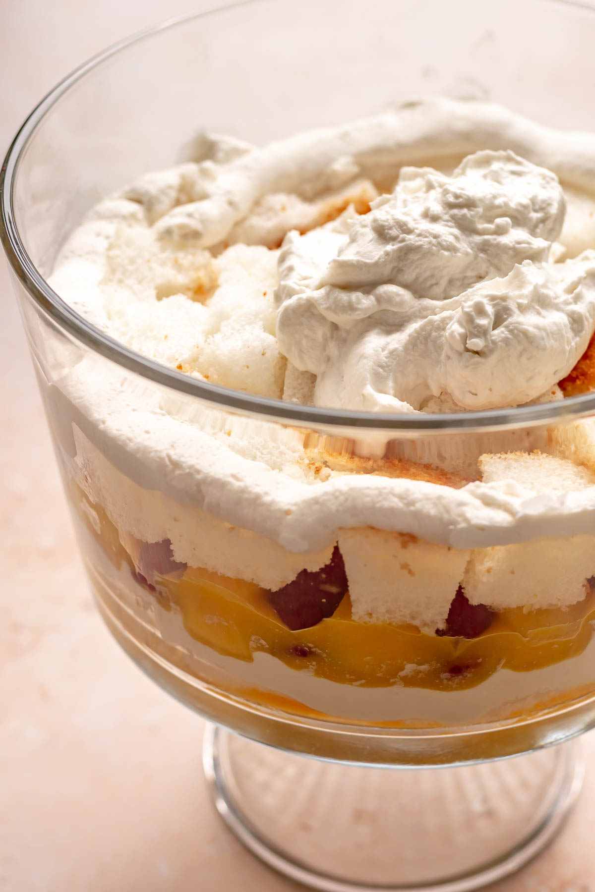Whipped cream dollop on top of fruit in a trifle bowl.