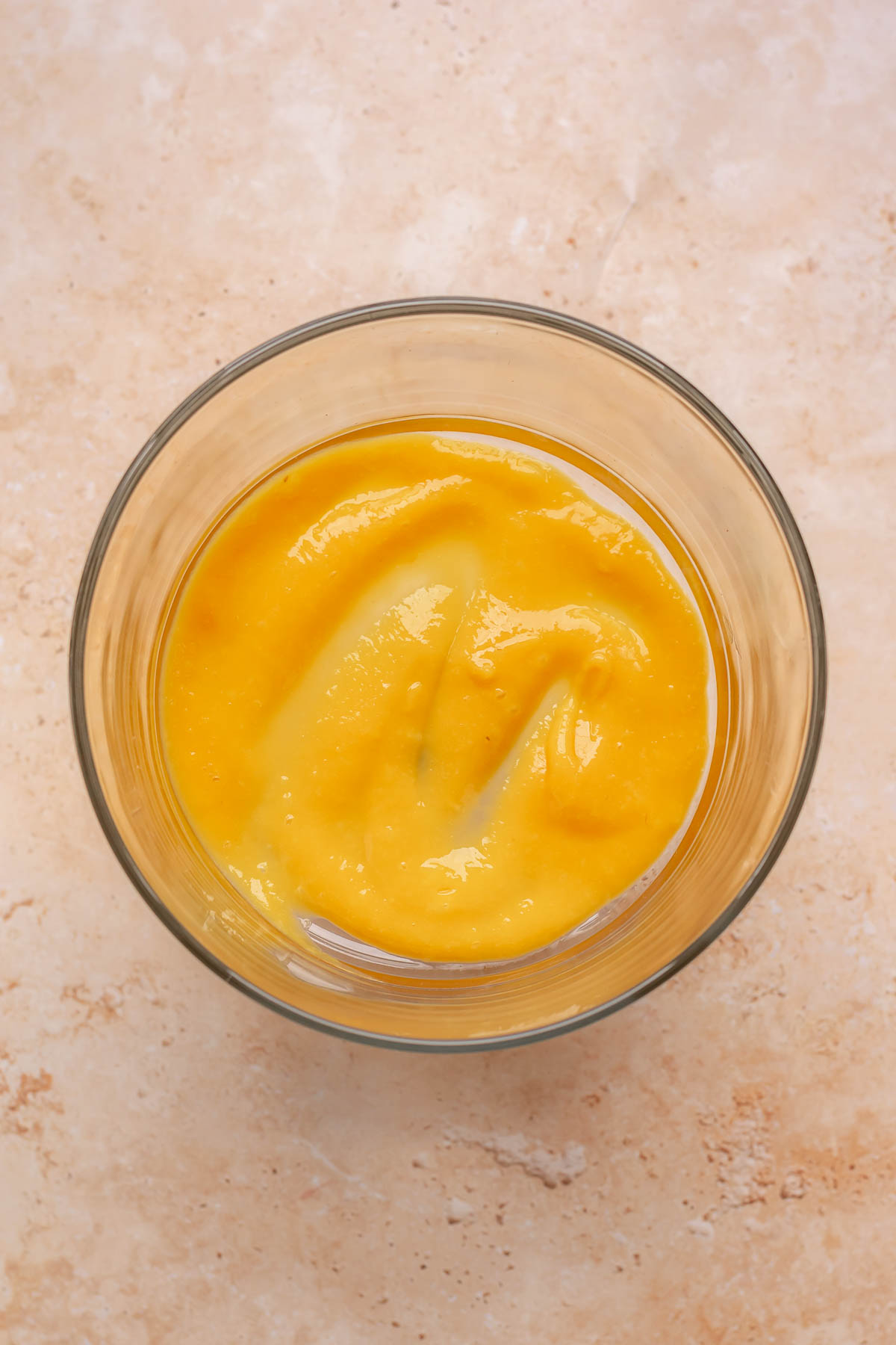 Mango puree in the bottom of a trifle bowl.