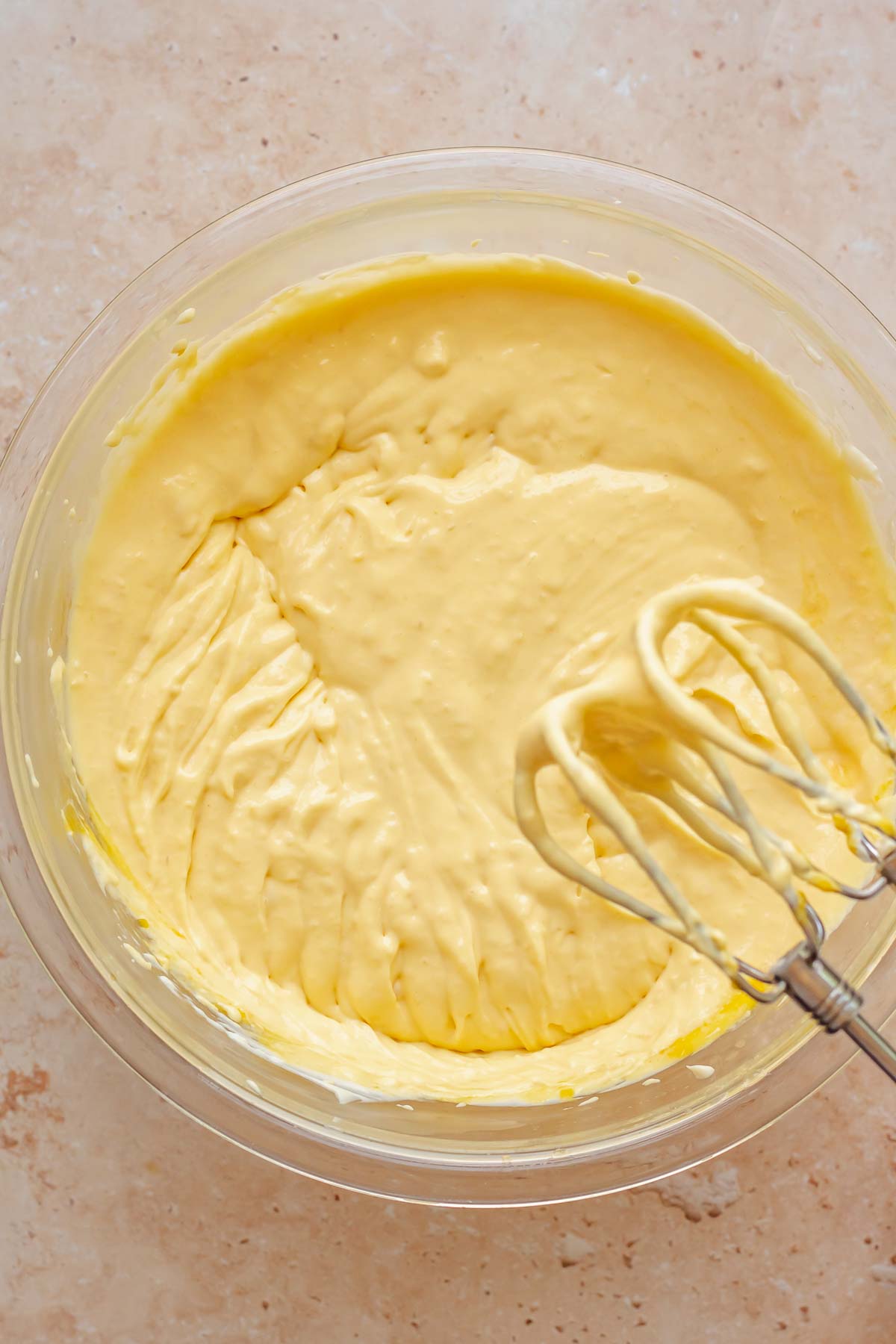 Beaters mix mango puree into cheesecake batter.