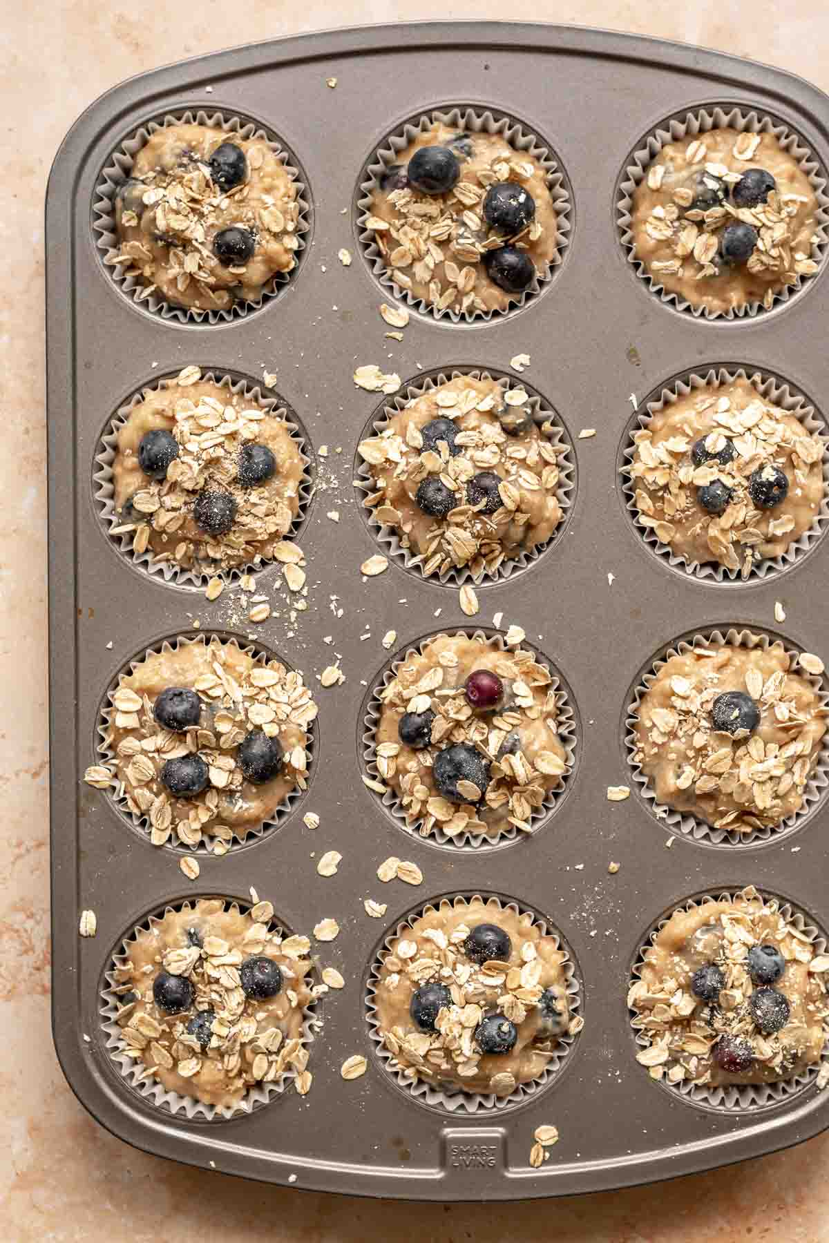 Pre-baked muffins with oats scattered on top.