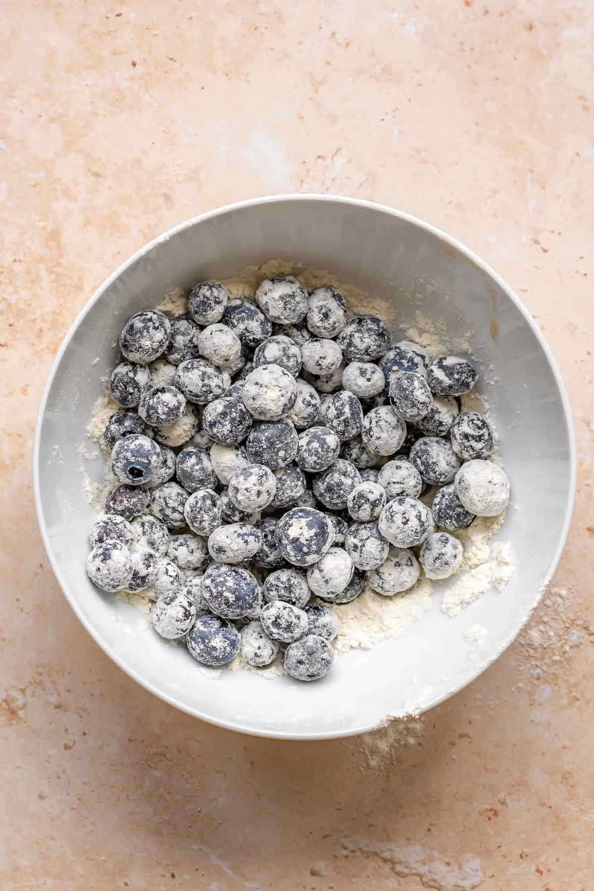 Blueberries coated in flour in a bowl.