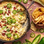 Jalapeno corn dip in a skilled with a serving spoon.