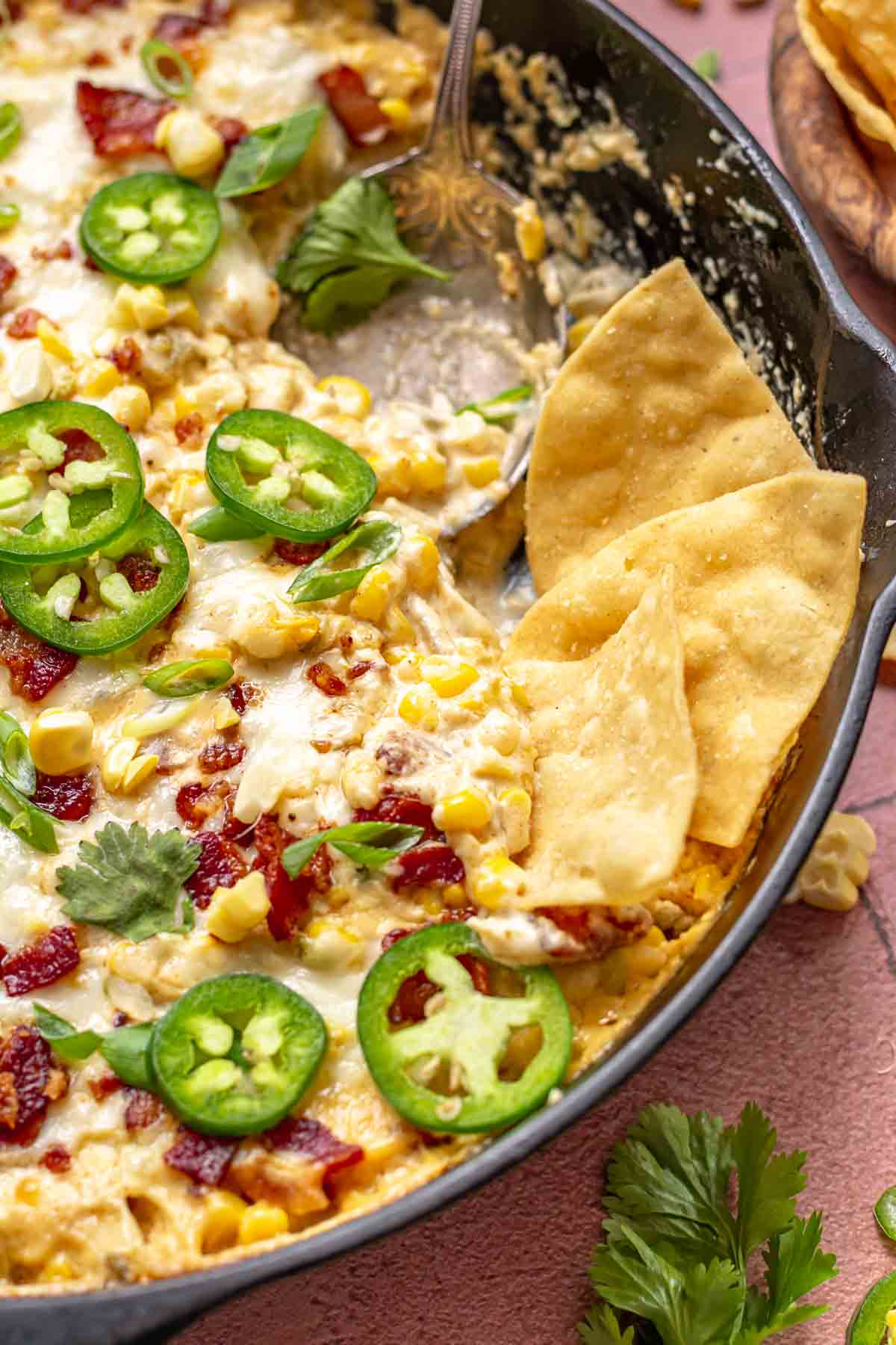Chips in a skillet with spicy corn dip.