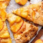 Sliced peach almond galette on parchment paper.