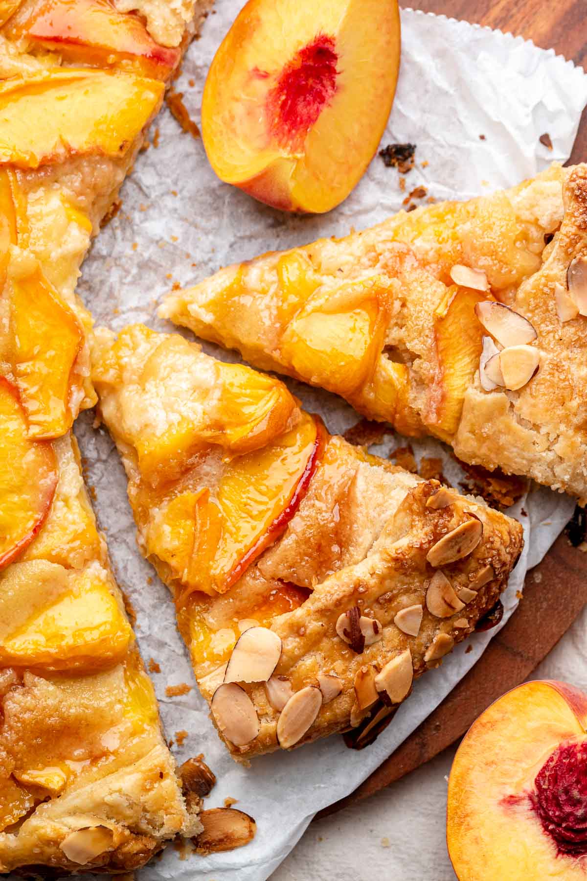 Sliced peach almond galette on parchment paper.