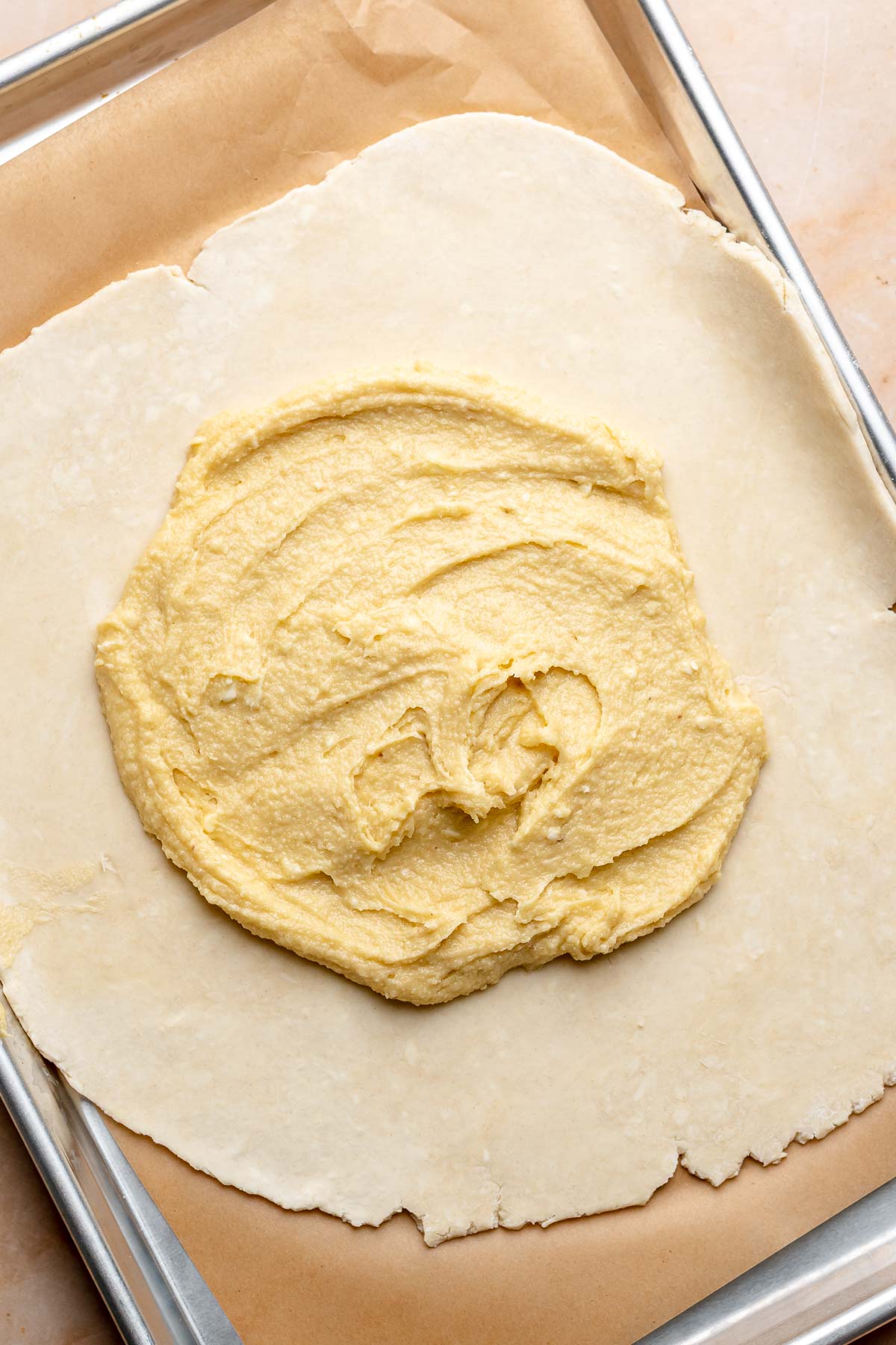 A circle of frangipane spread onto a rolled out pie crust.