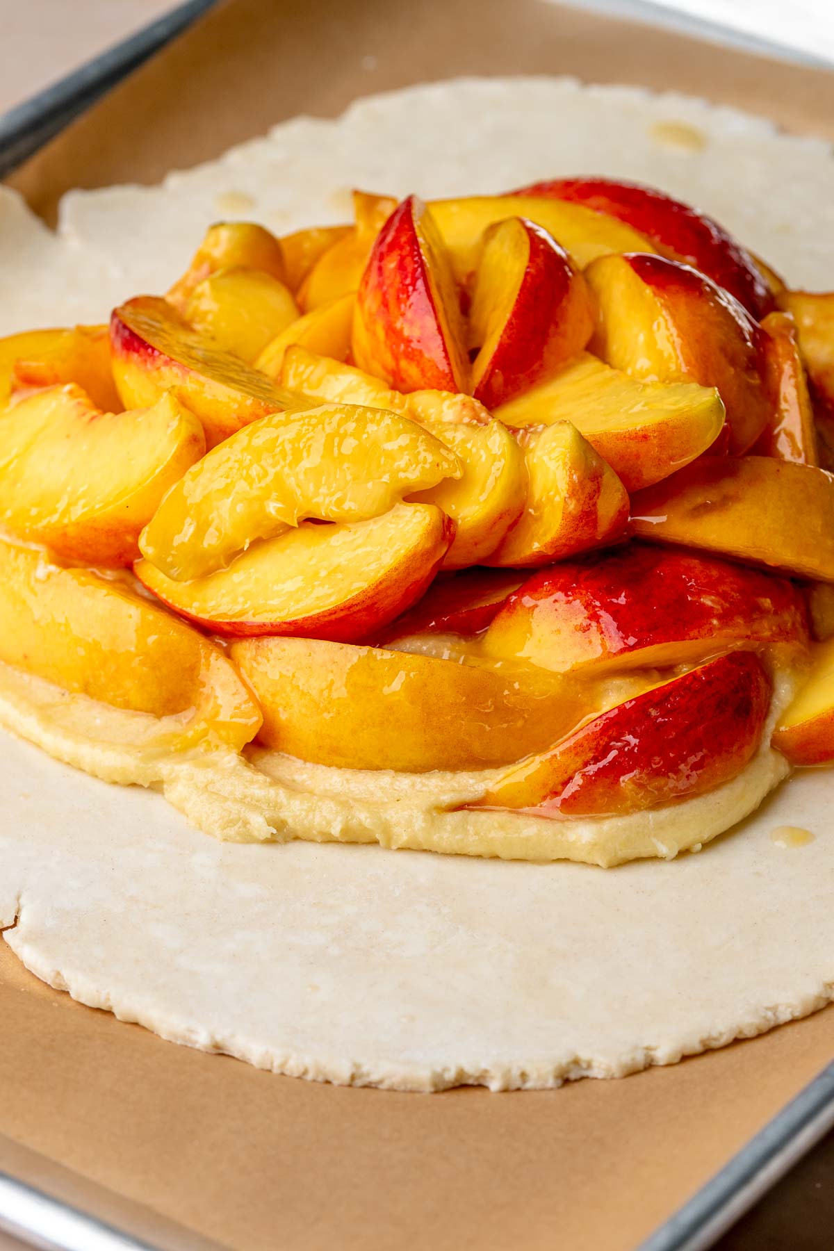 Sliced peached layered on top of frangipane and pie crust.