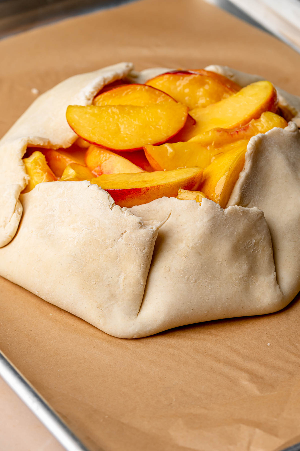 Pie crust folded around peaches.
