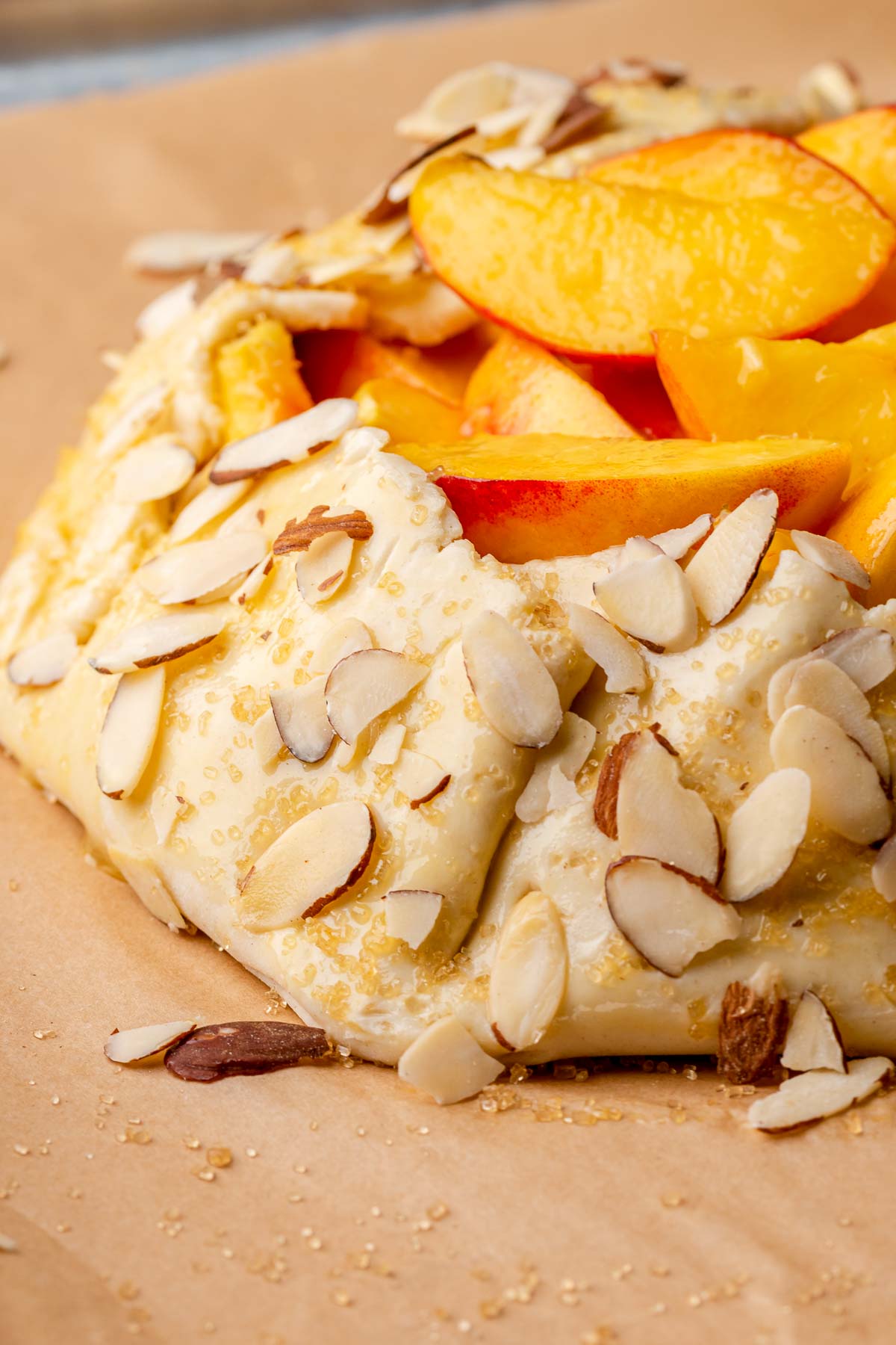 Fully assembled peach galette on a sheet pan.