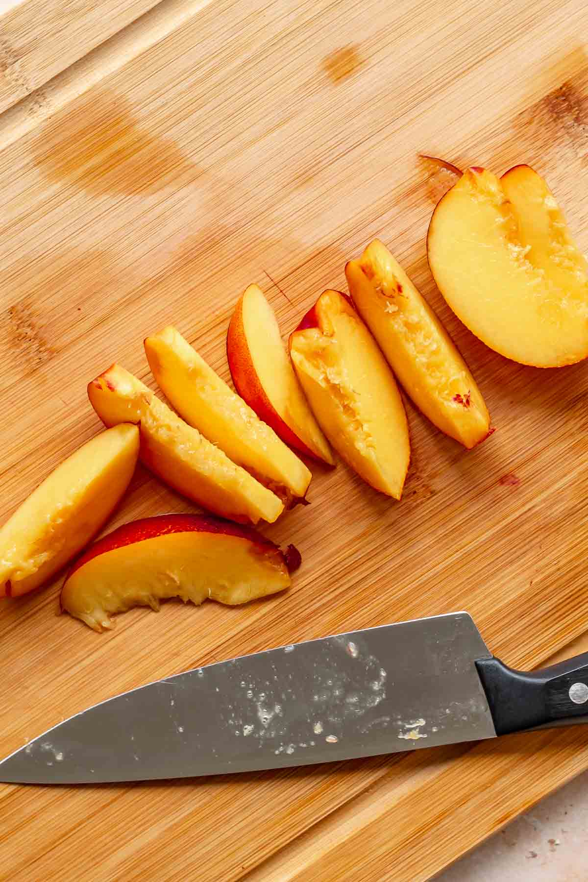 Peach slices on a cutting board.