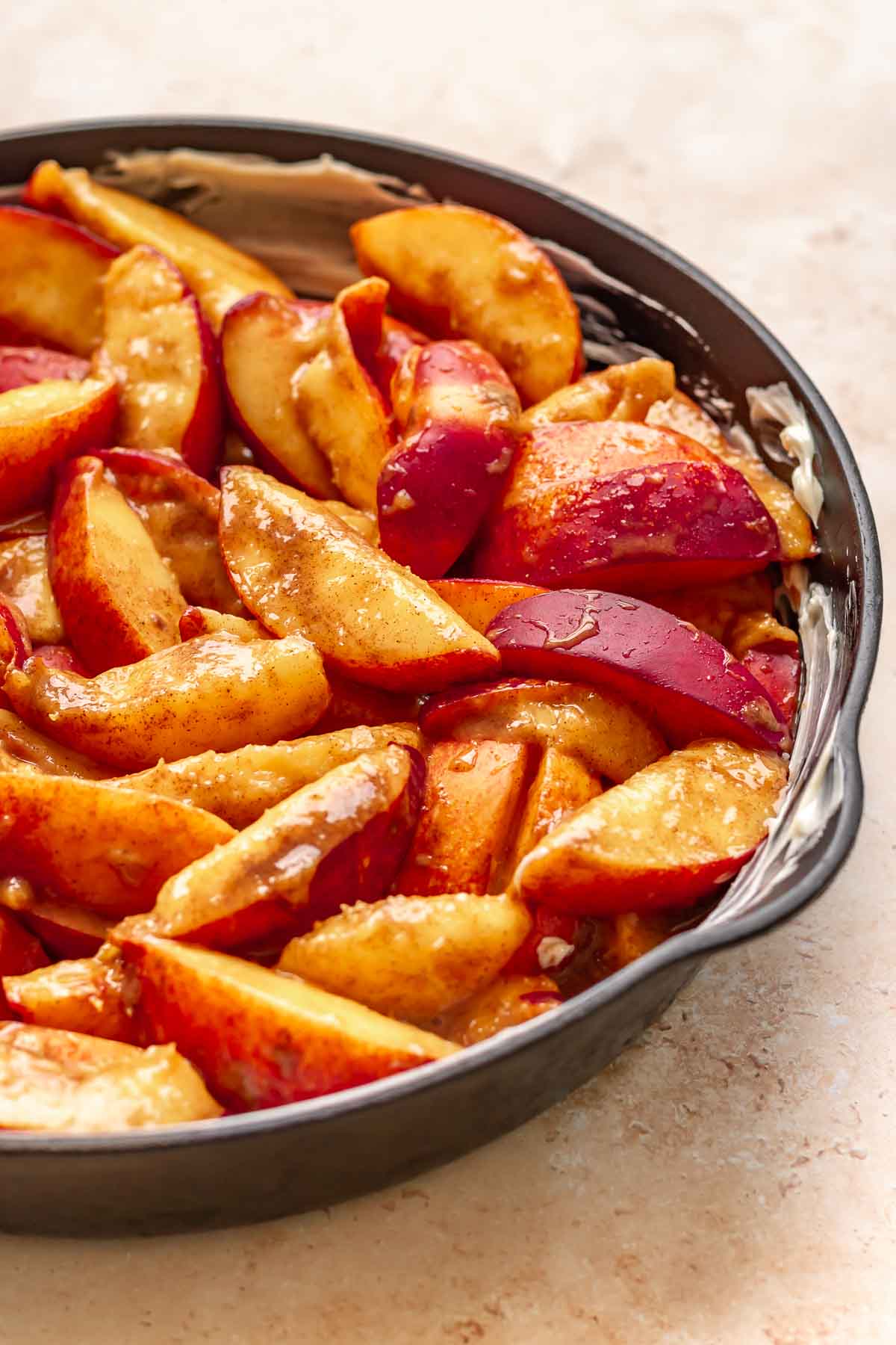 Spiced peach slices in a cast iron skillet.