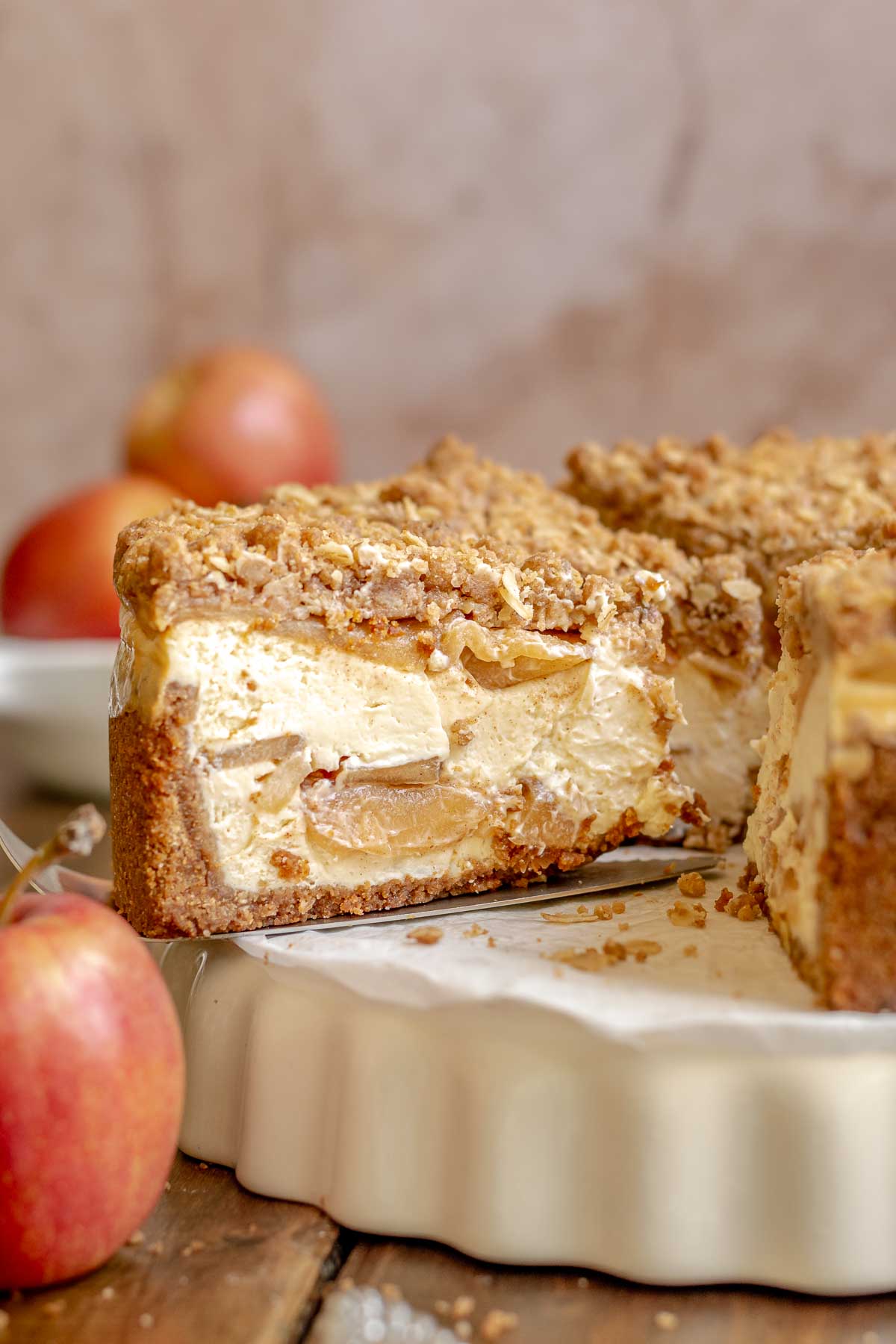 Apple crumble cheesecake cut on a platter.