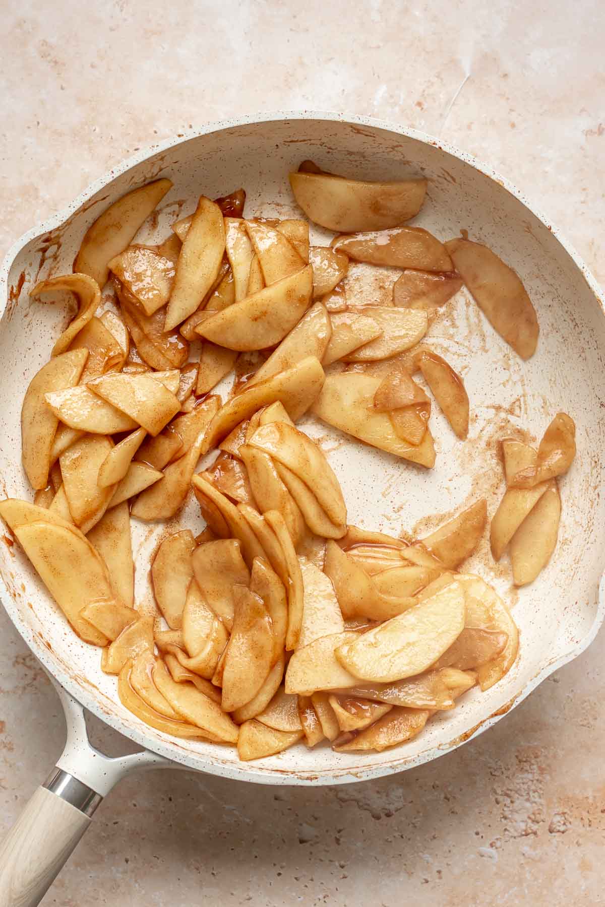 Cooked apple slices in a frying pan.