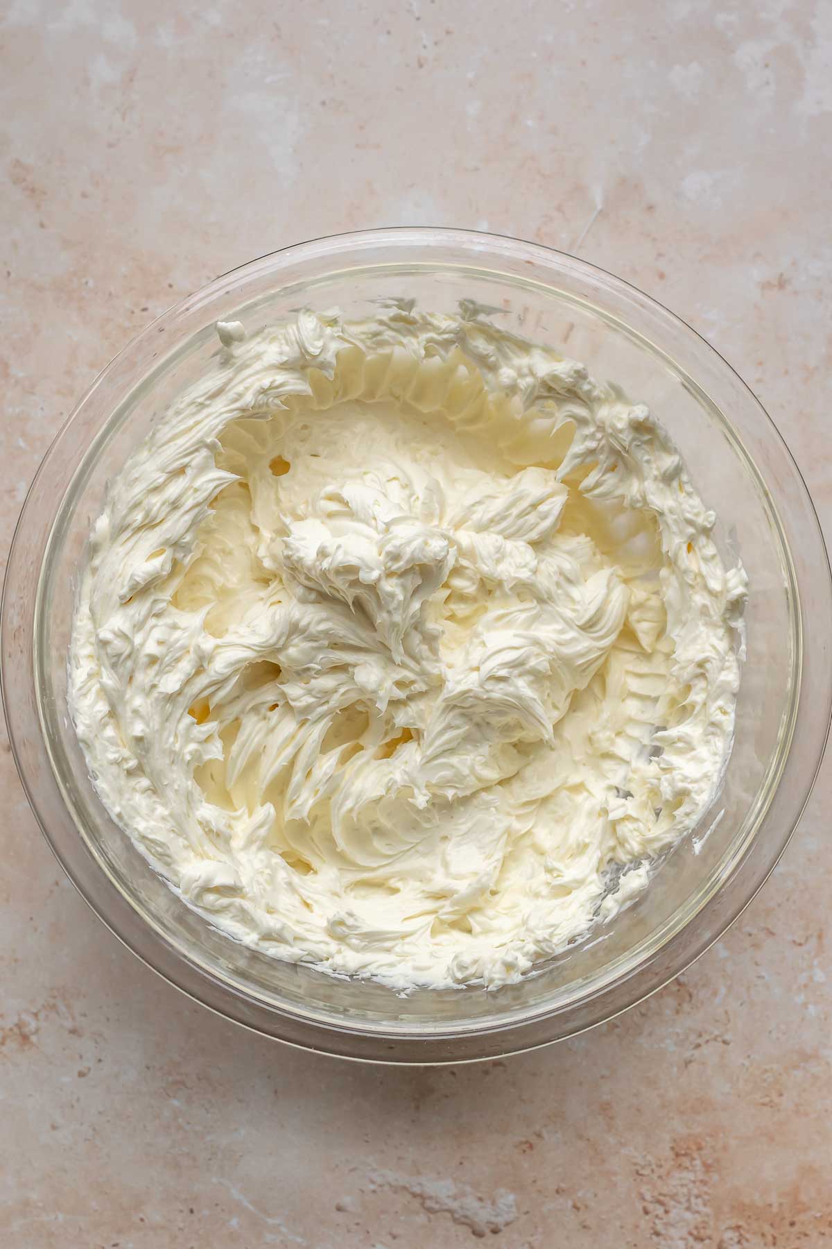 Cream cheese whisked in a mixing bowl.