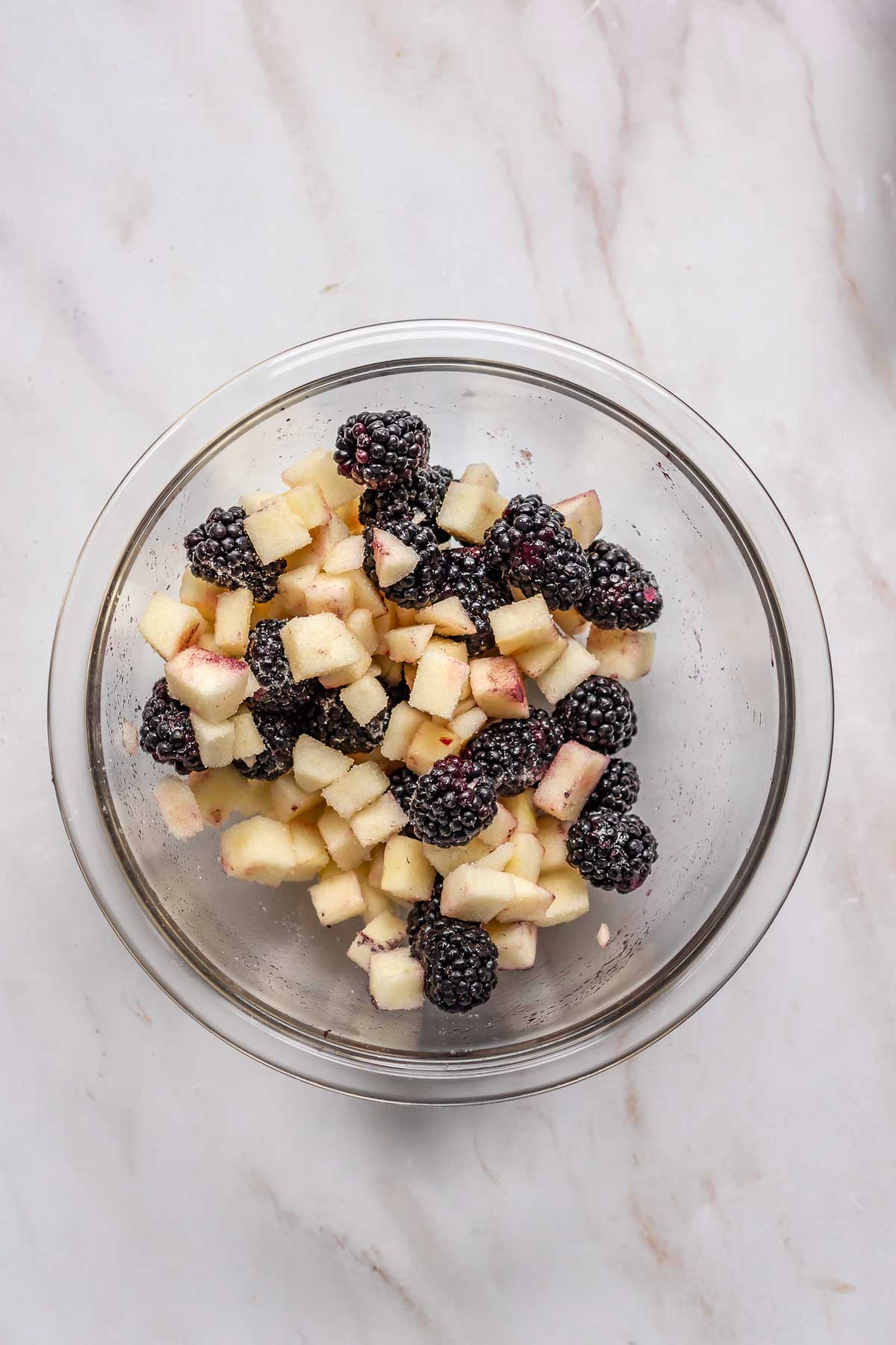 Blackberries and apples in a mixing bowl.