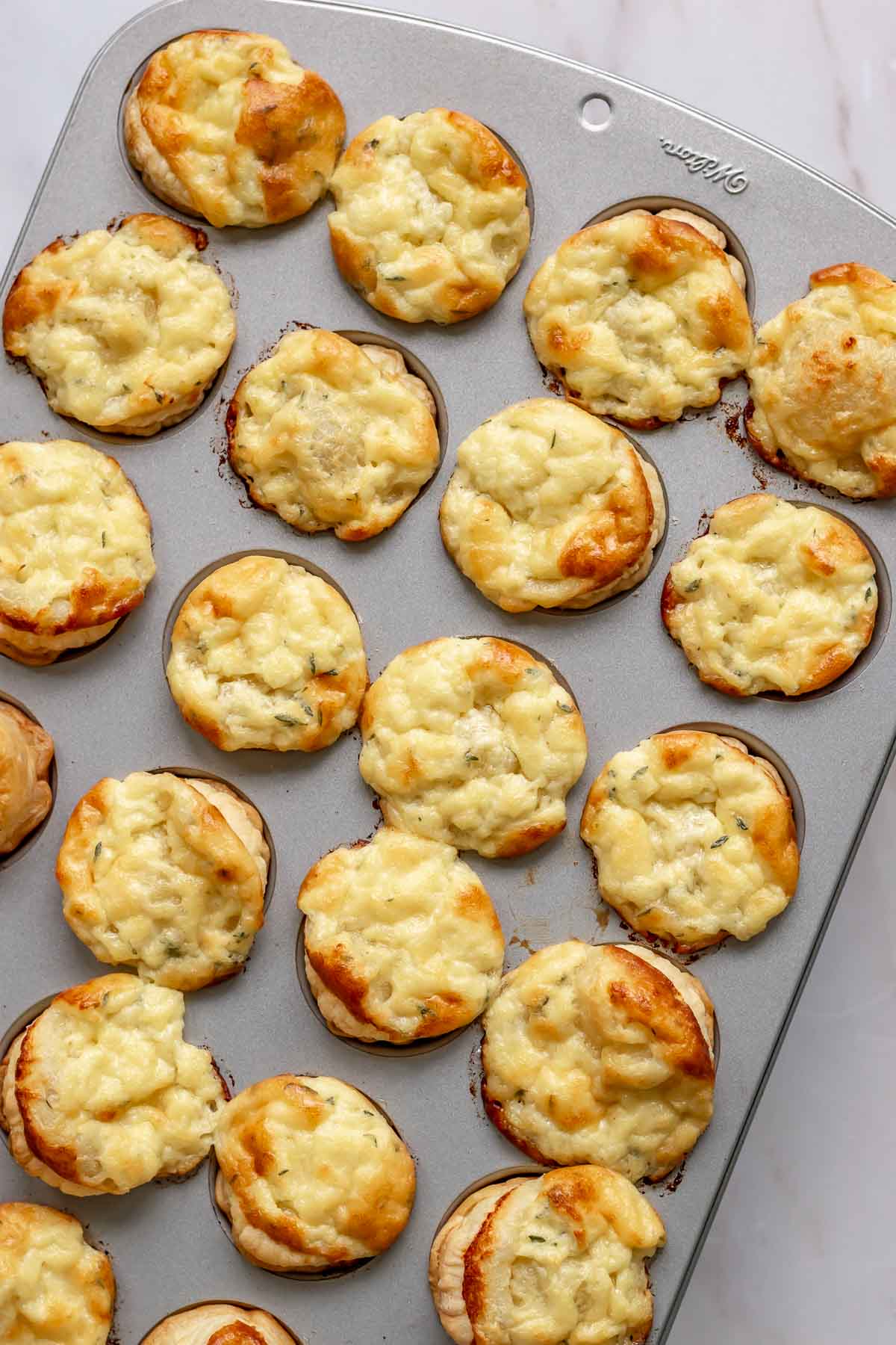 Puffed up, baked cheese tartlets in a muffin tin.