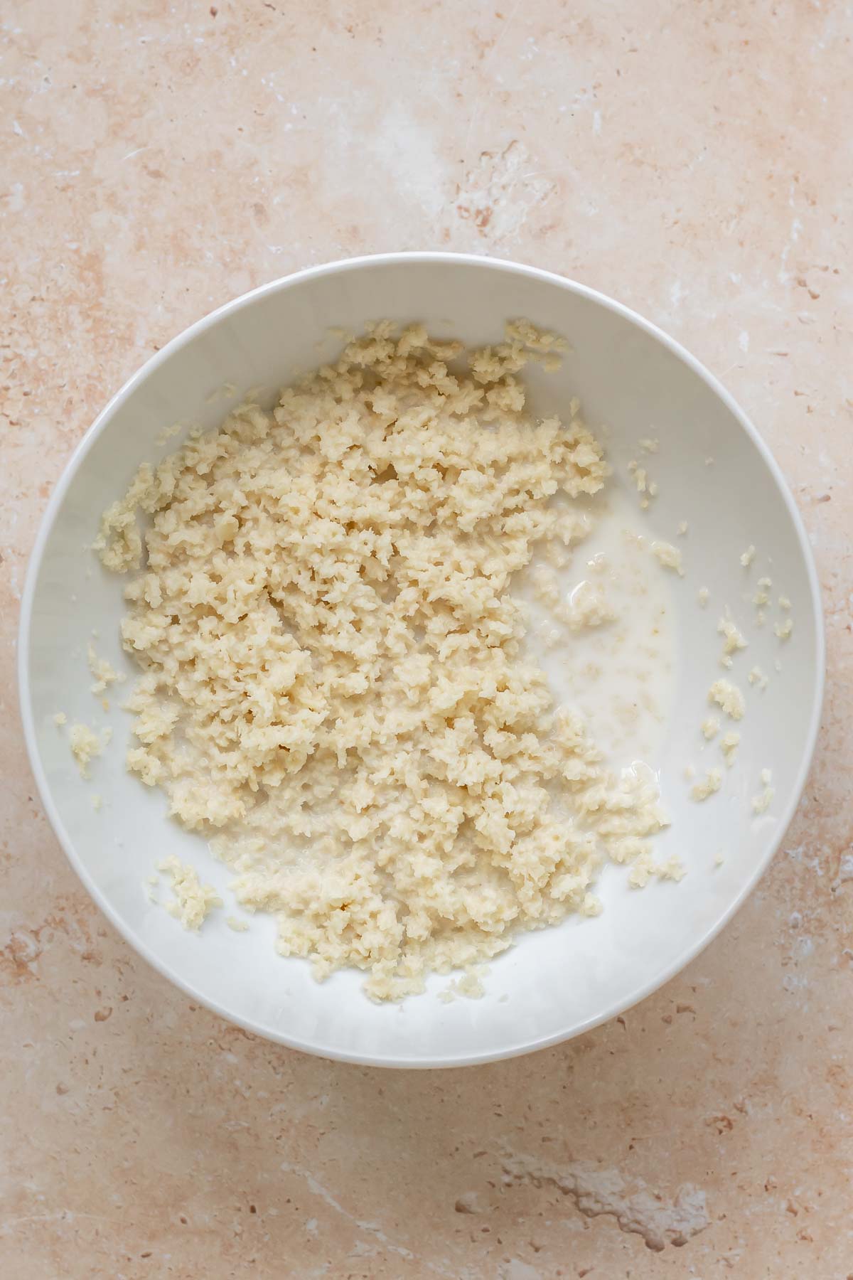 Panko bread crumbs and milk in a bowl.