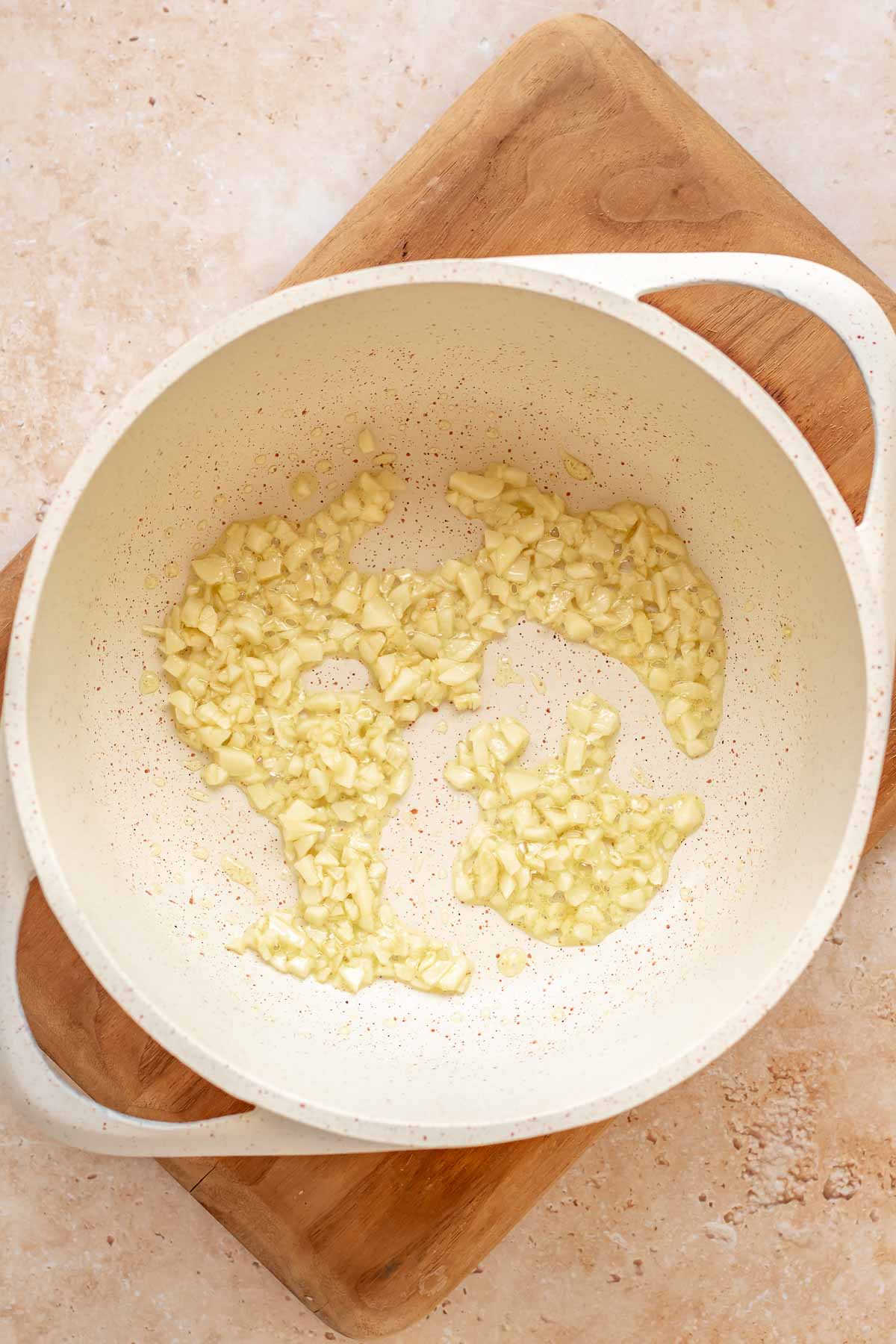 Garlic sautéing in a saucepan.