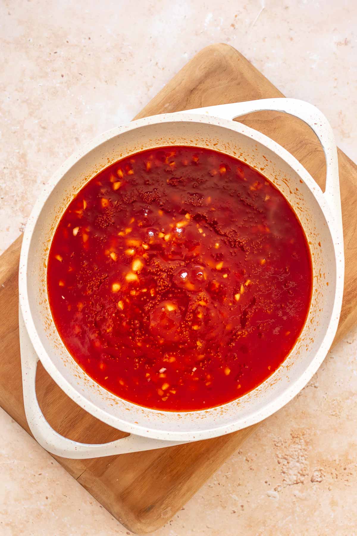 Ingredients for honey sriracha sauce mixed together in a saucepan.