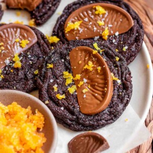 Chocolate orange cookies on a plate with orange sugar next to them.