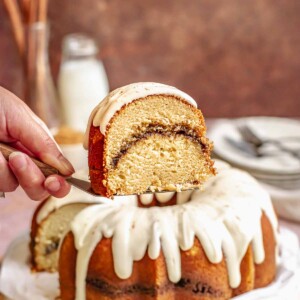 A slice of cinnamon bundt cake being held up on a spatula.