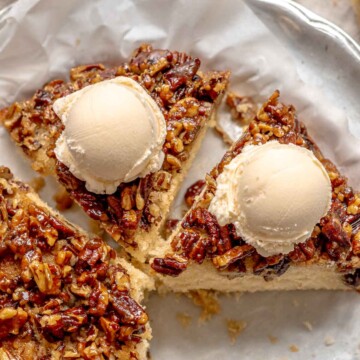 Slices of upside down pecan cake with ice cream on top.
