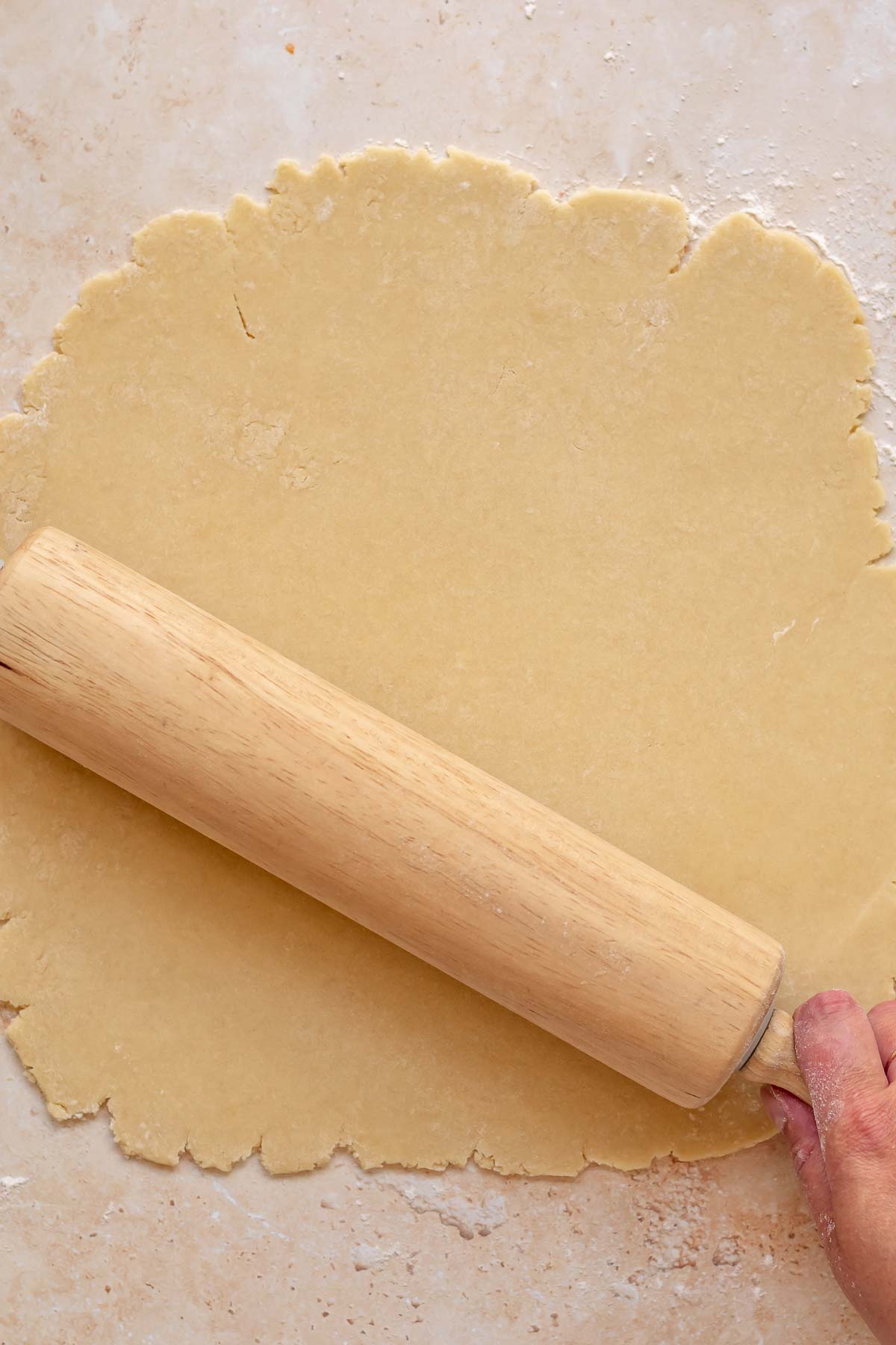 A rolling pin rolls out sweet tart dough.