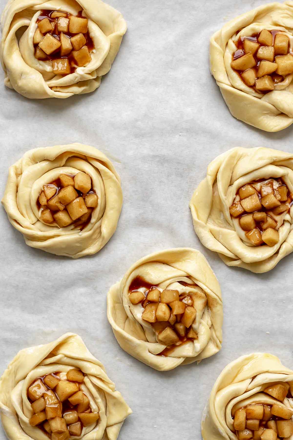 Apple pie filling in the center of all puff pastry roses.